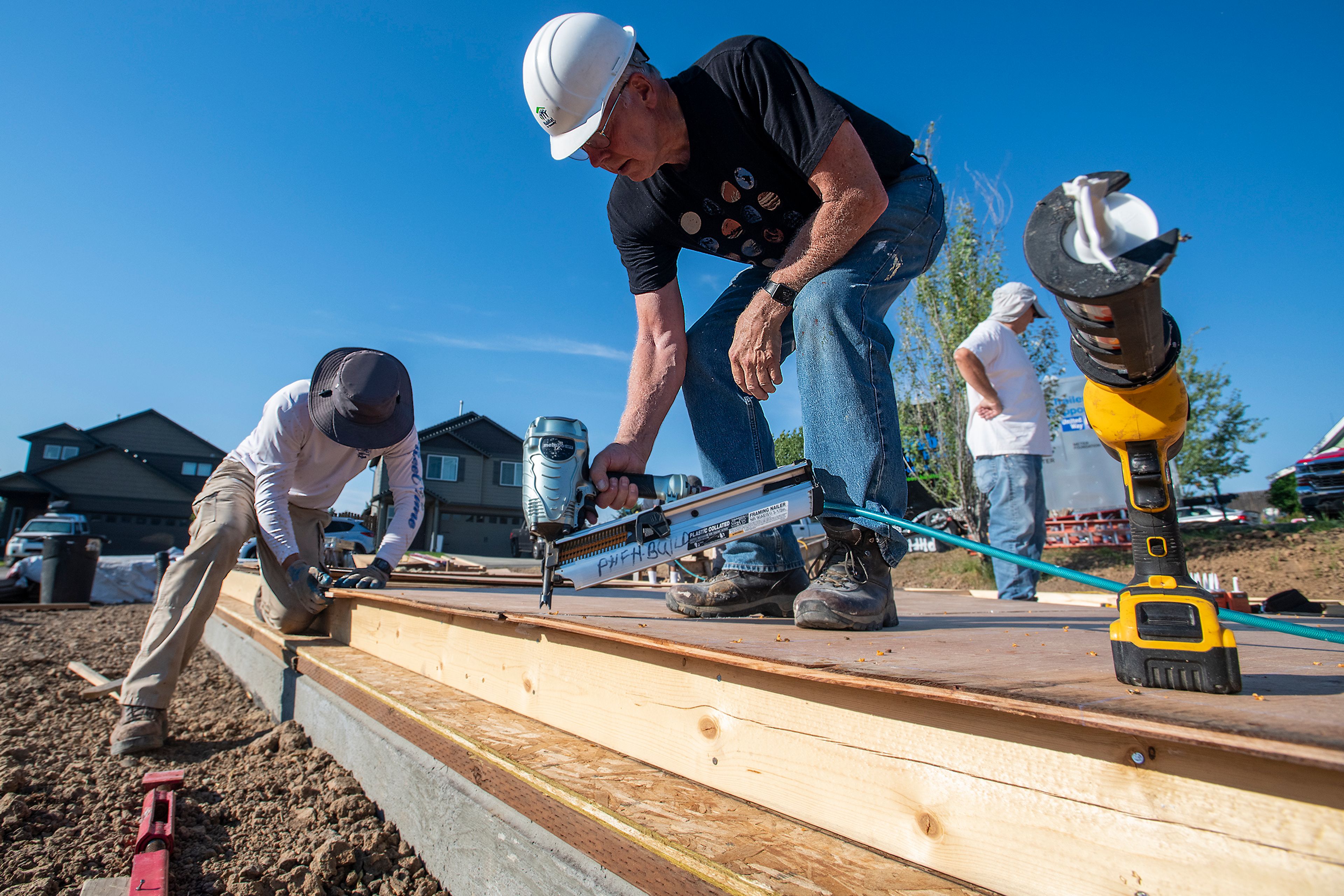 Volunteers Mike Bisbee, left, and Jay Hunter work on a wall while constructing a home with Palouse Habitat for Humanity in Moscow.