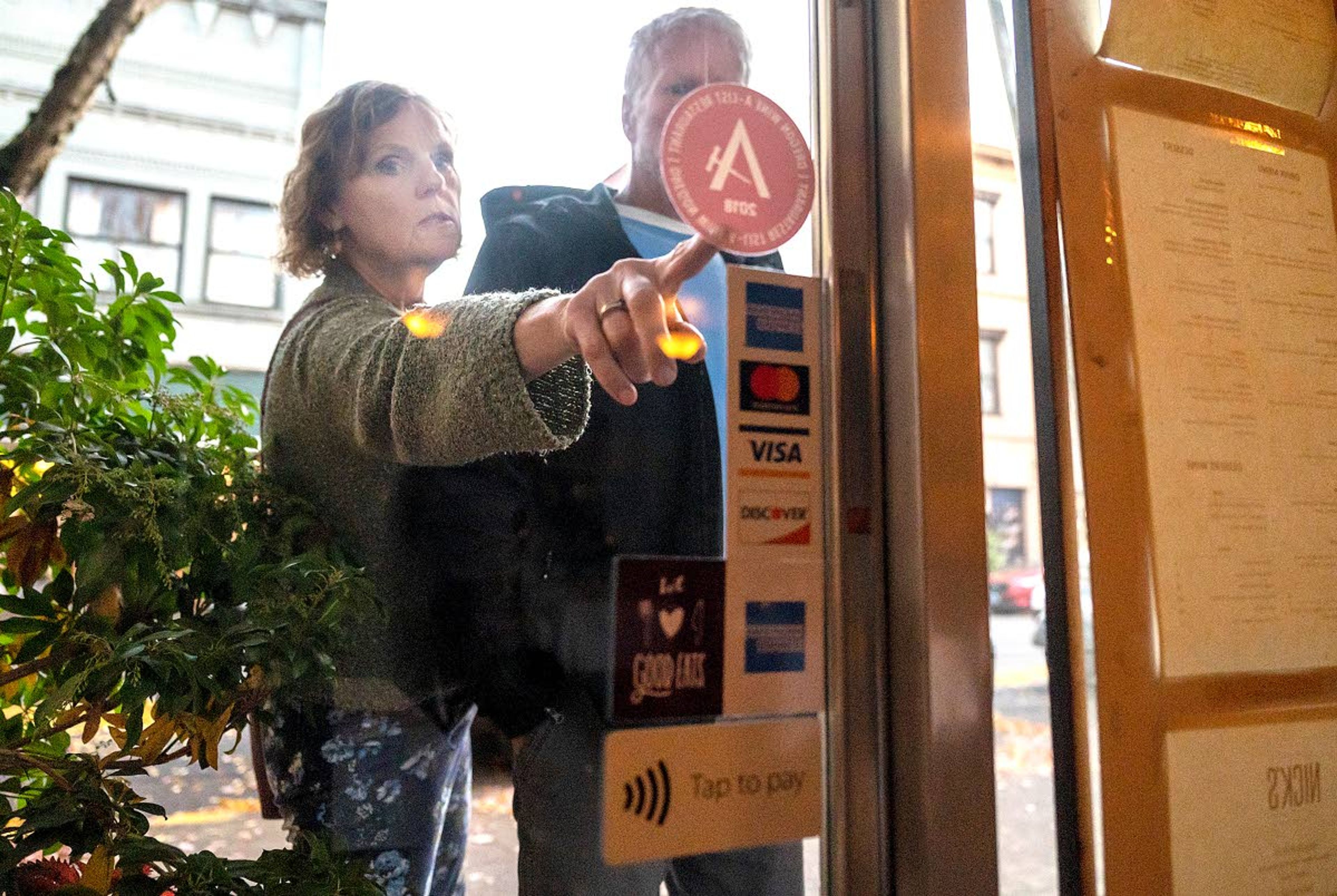 Potential patrons to Nick’s Italian Cafe give the menu a once over before entering the James Beard Award winning restaurant in downtown McMinnville.