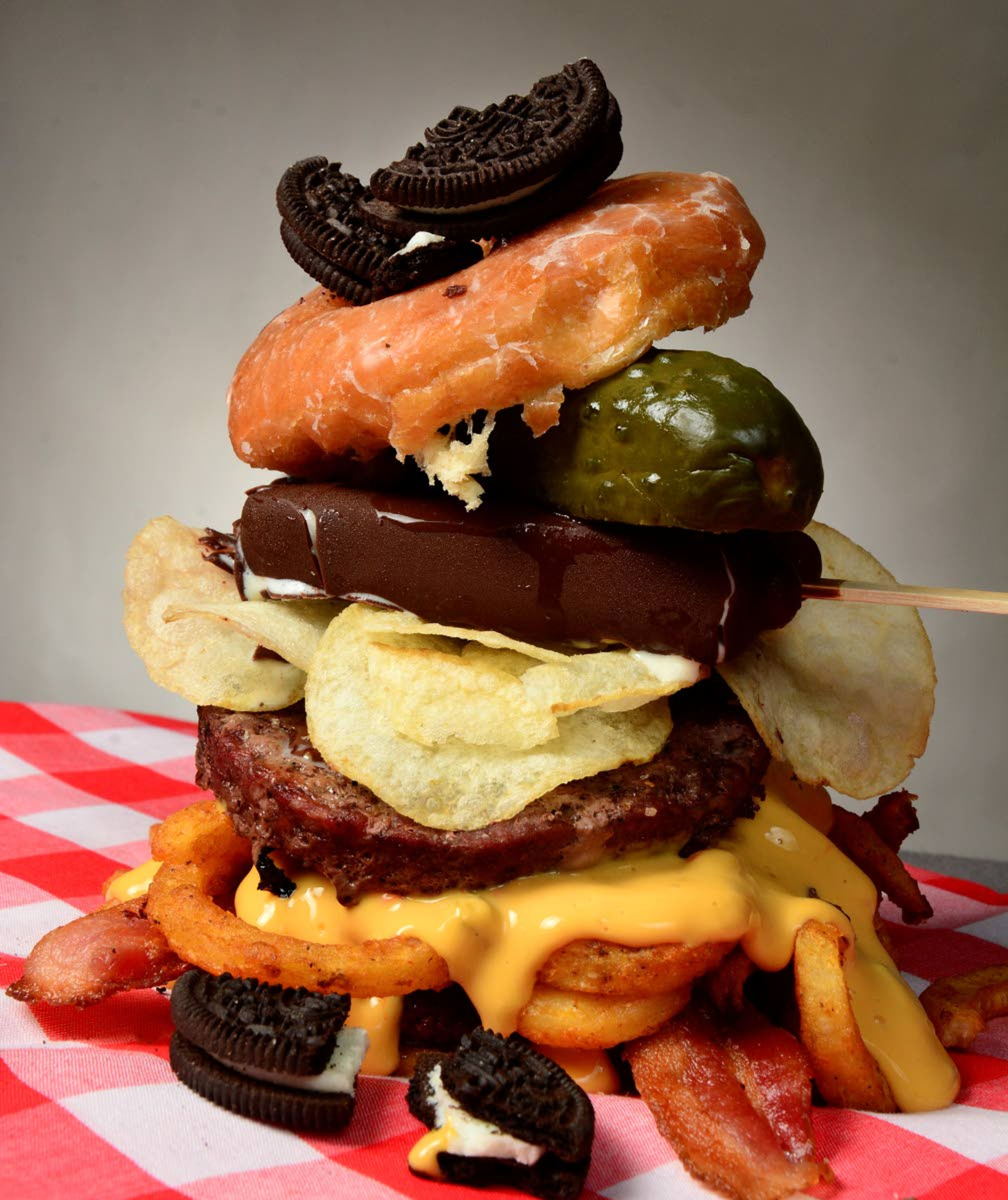 Outdoing Dagwood: Fair food is all about excess. Here are the ingredients for Inland 360’s ultimate fair food burger, from bottom to top: glazed doughnut, bottom half; hamburger patty; bacon; curly fries; nacho cheese sauce; hamburger patty; potato chips; ice cream bar; one whole pickle; glazed doughnut, top half; Oreos, crushed.