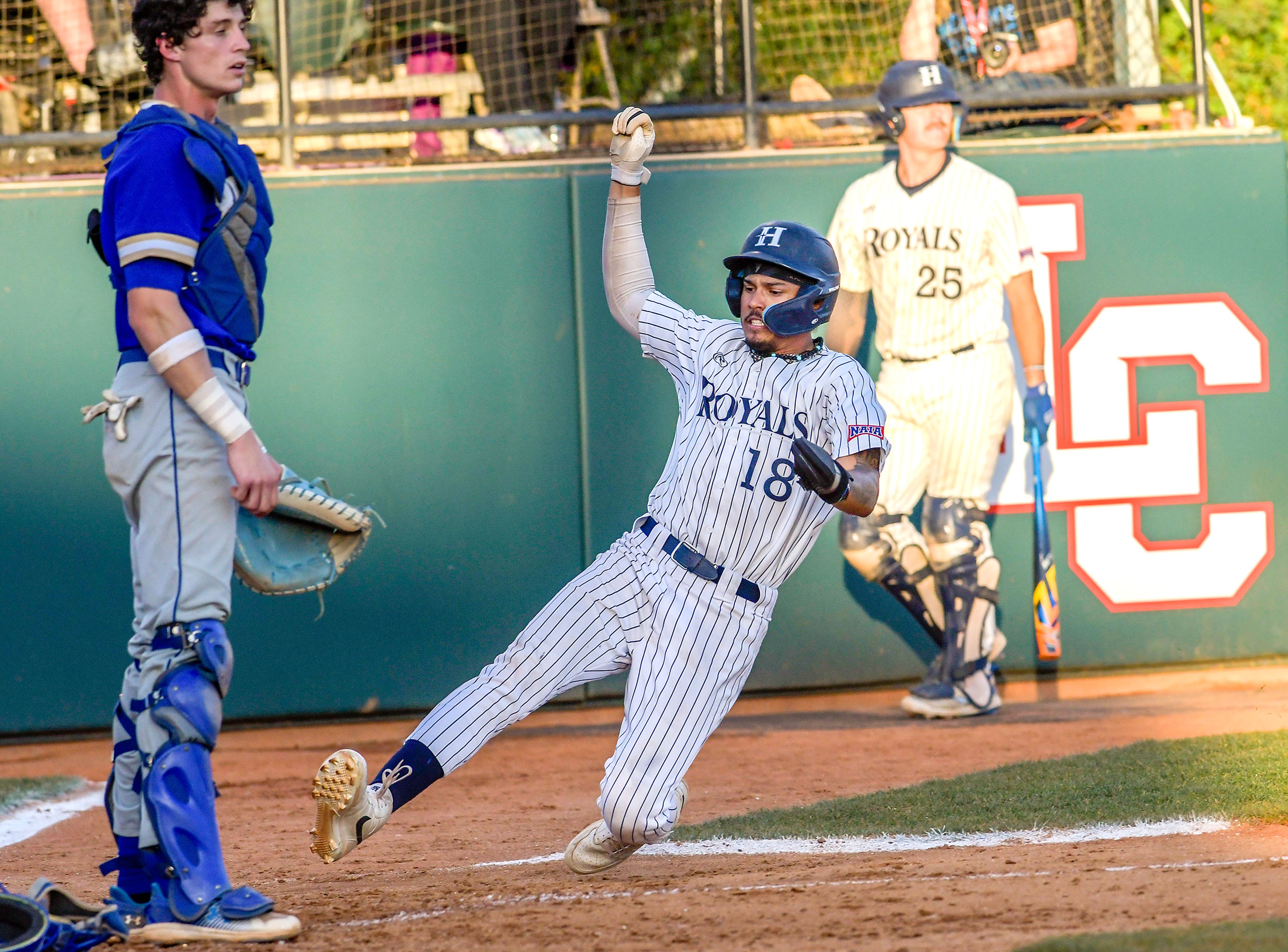 Hope International’s Amari Bartee goes into a slide to score against Tennessee Wesleyan in Game 19 of the NAIA World Series at Harris Field Friday in Lewiston.