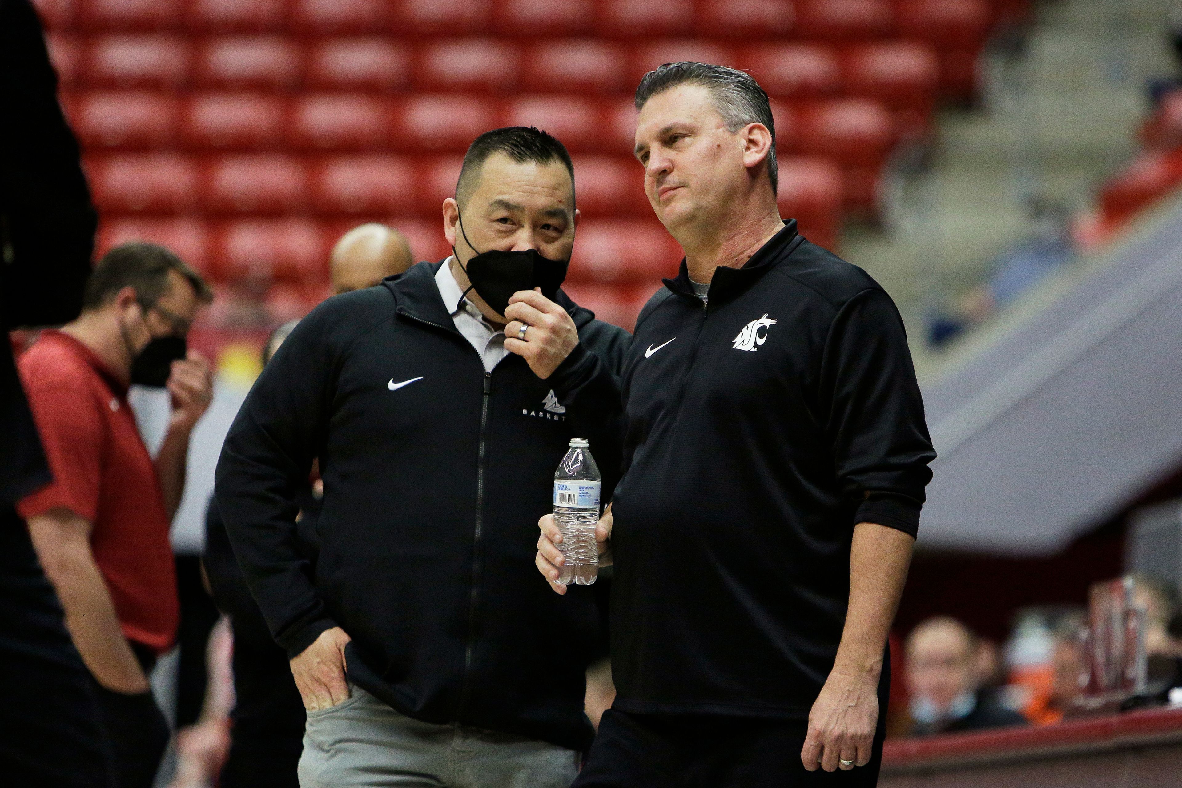 Washington State athletic director Pat Chun, left, speaks with coach Kyle Smith during a delay before a game against Stanford on Jan. 13, 2022, in Pullman.