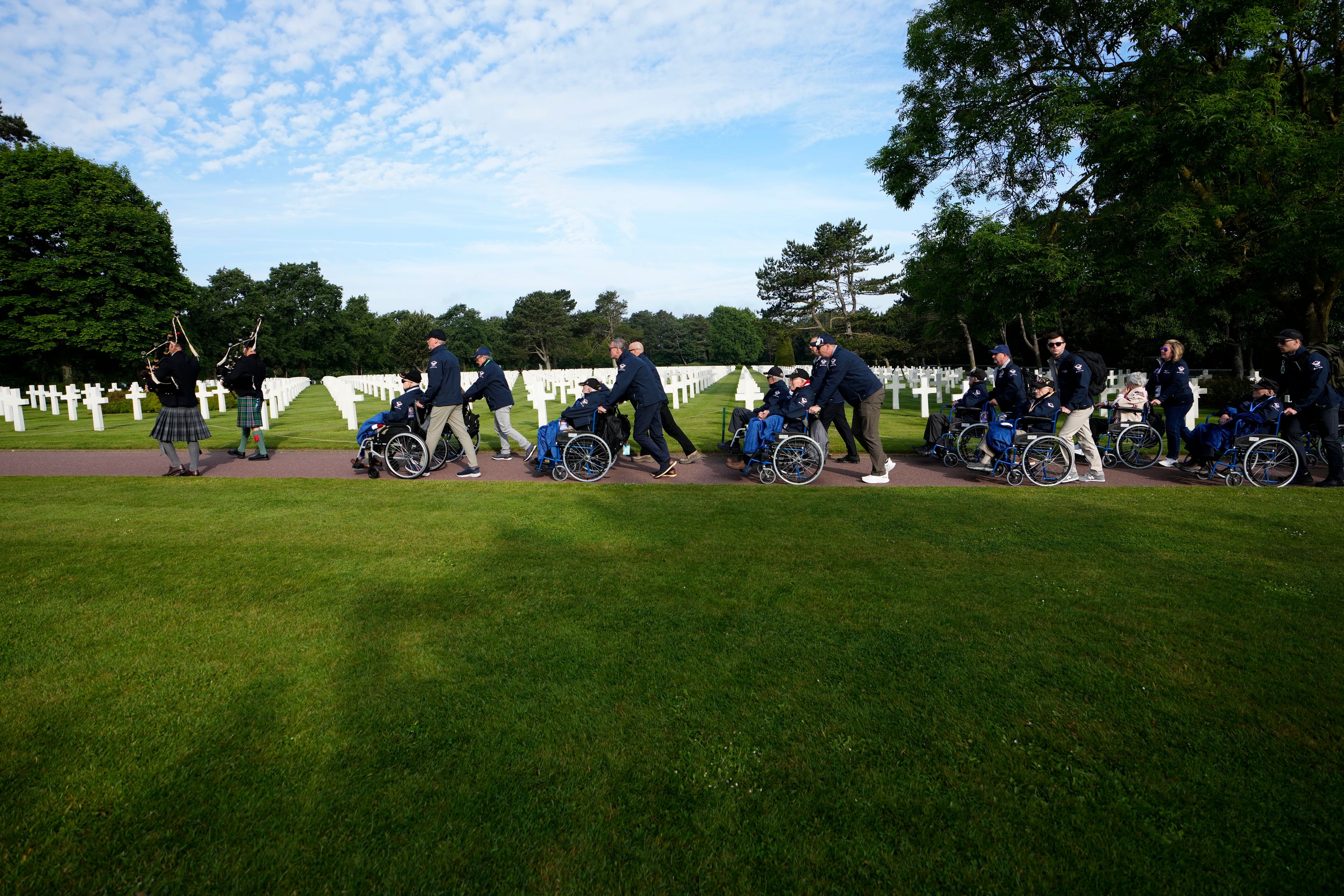 World War II and D-Day veterans visit graves at the Normandy American Cemetery in Colleville-sur-Mer, Tuesday, June 4, 2024. World War II veterans from across the United States as well as Britain and Canada are in Normandy this week to mark 80 years since the D-Day landings that helped lead to Hitler's defeat. (AP Photo/Virginia Mayo)