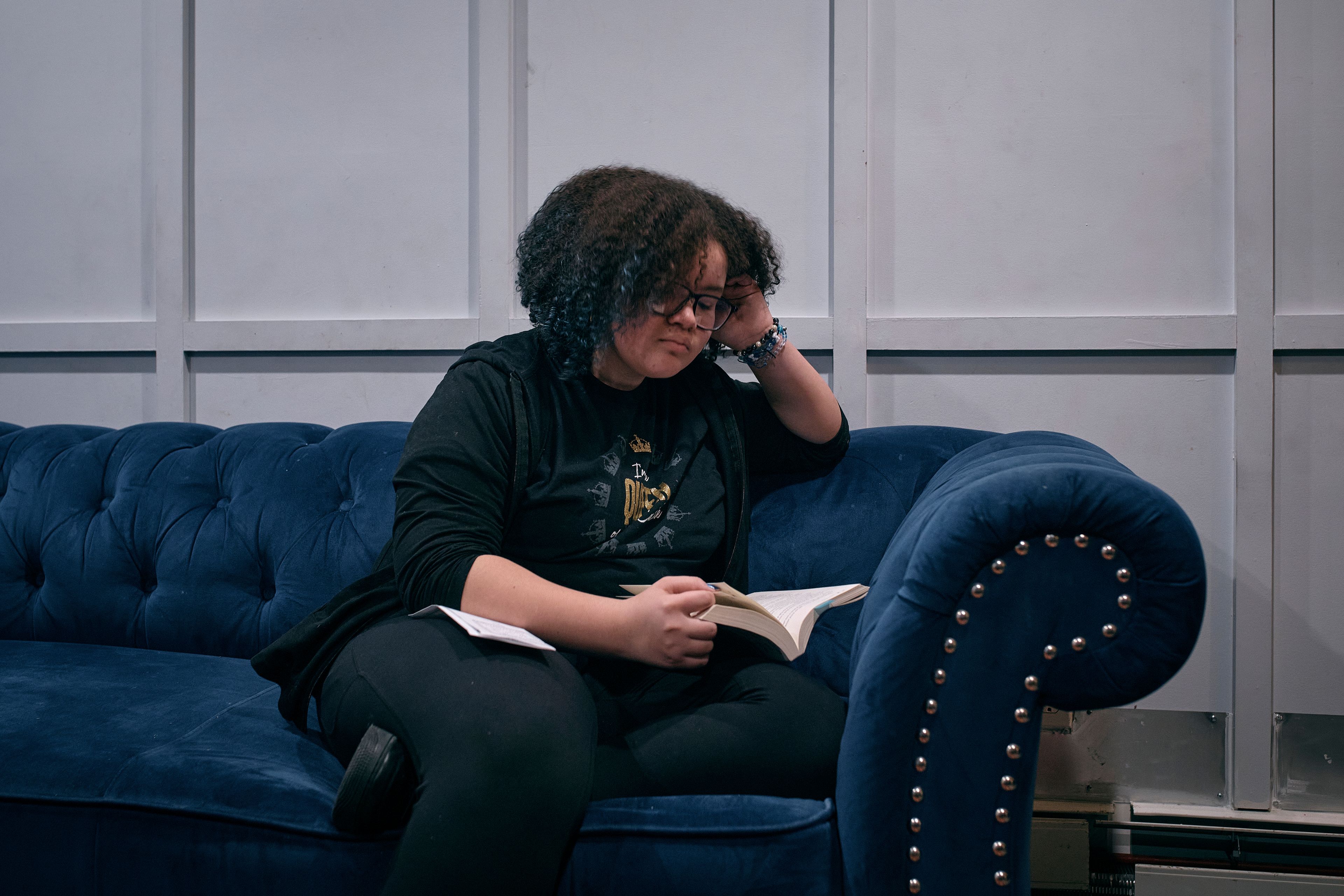 Gionna Durham, 13, reads a book on the sofa on Saturday, Jan. 27, 2024, in New York. With the damaging consequences of social media increasingly well documented, many parents are trying to raise their children with restrictions or blanket bans. Teenagers themselves are aware that too much social media is bad for them, and some are initiating social media “cleanses” because of the toll it takes on mental health and grades.