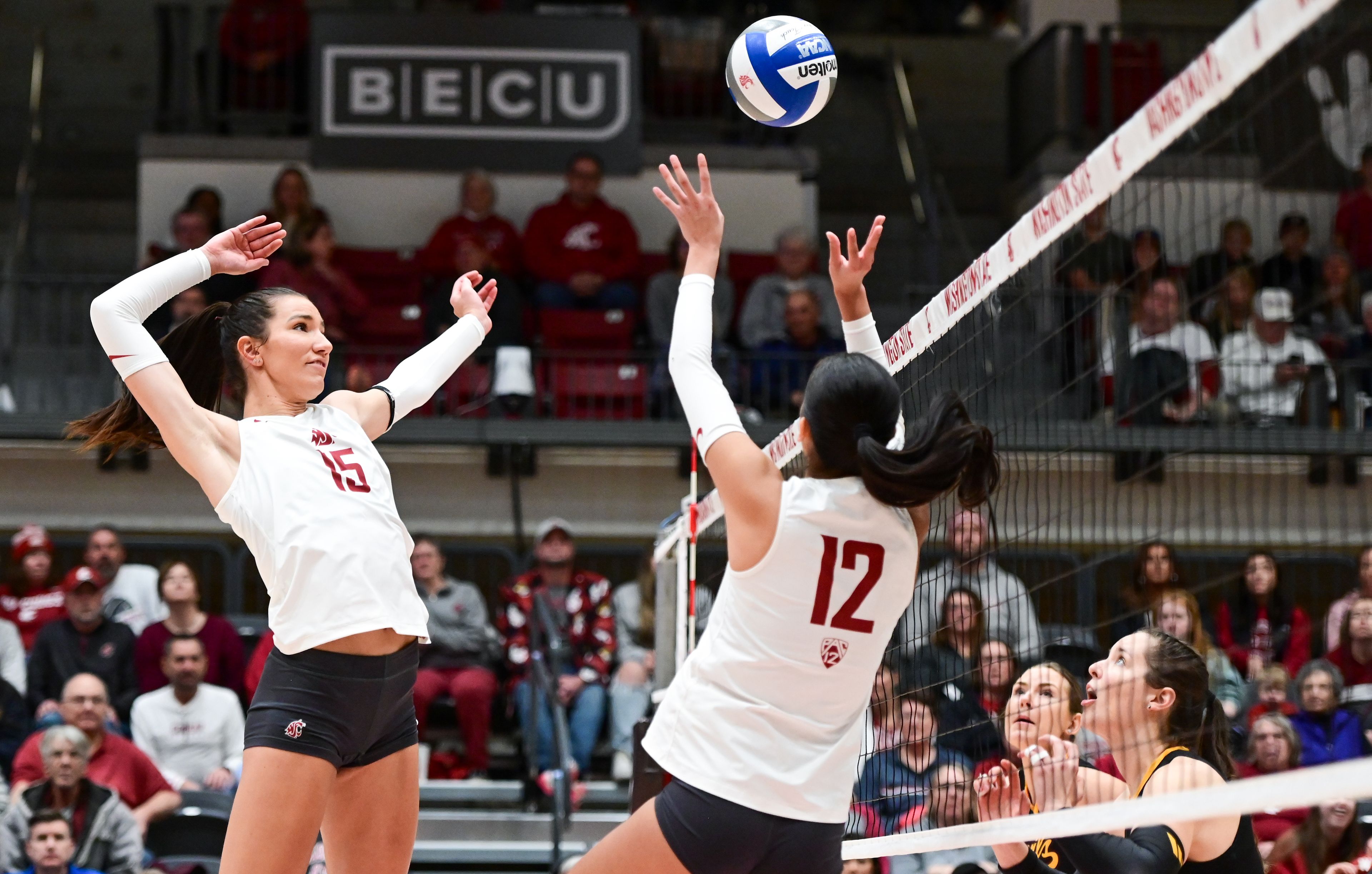 Washington State middle blocker Magda Jehlárová (15) jumps to spike a pass from setter Argentina Ung (12) during a match against Arizona State on Nov. 22 at Bohler Gym in Pullman.