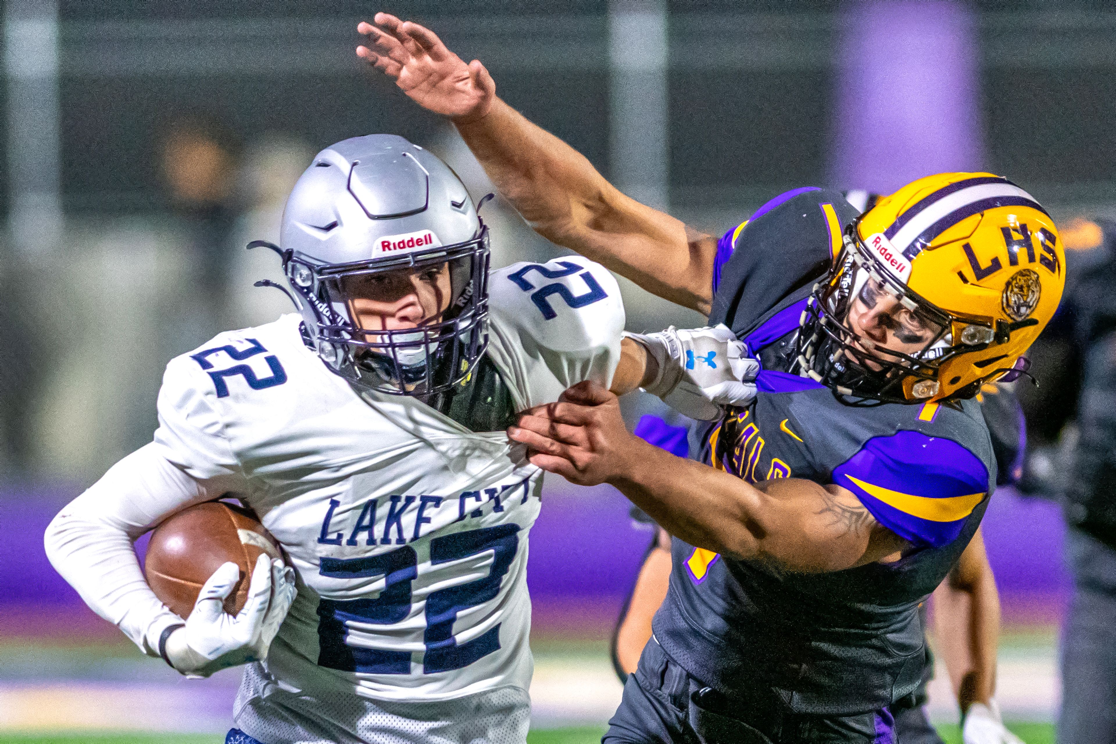 Lake City running back Gabe Wullenwaber stiff arms Lewiston linebacker Layden Cobley as he looks to bring him down on a run in a nonconference game Friday at Lewiston High School.,