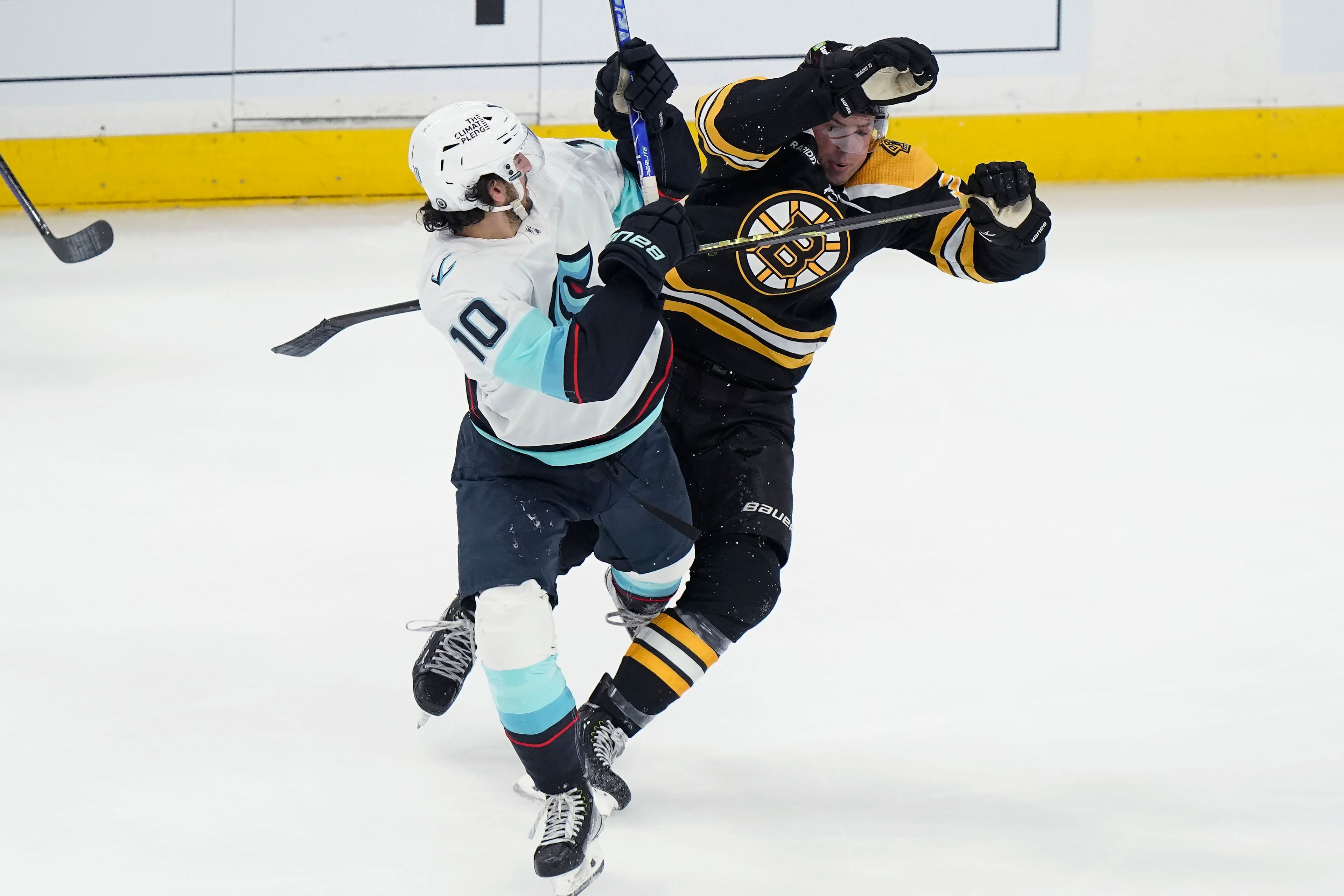 Seattle Kraken center Matty Beniers (10) and Boston Bruins defenseman Charlie McAvoy (73) collide during the second period of an NHL hockey game Thursday, Jan. 12, 2023, in Boston. (AP Photo/Steven Senne)