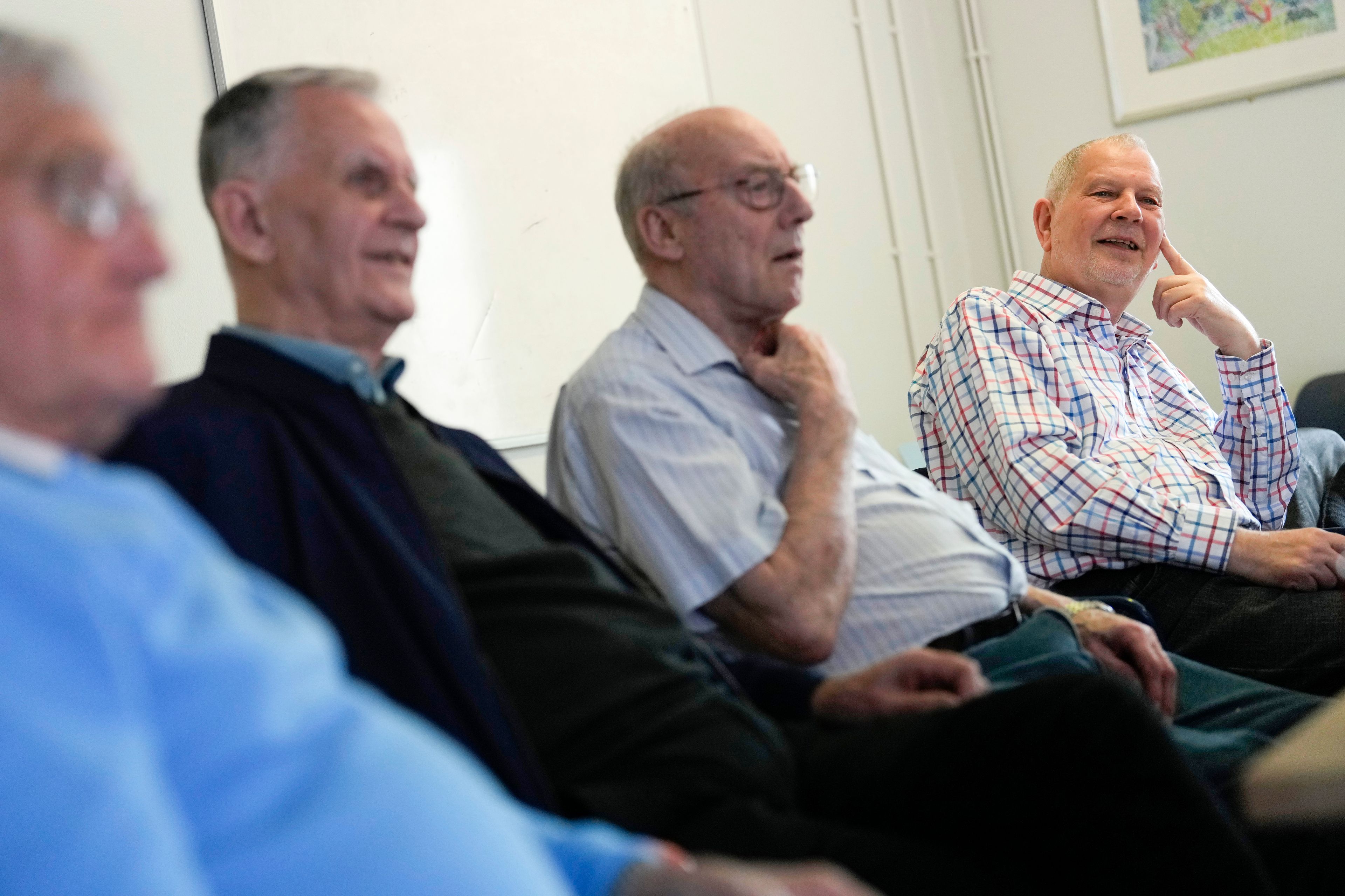 Alan Tucker, right, gestures as he speaks at the weekly lunch meeting of some 20 retired men at the Tredegar community centre in Bow, in east London, Thursday, May 16, 2024. Passing around plates of cheese and crackers and slices of crème cake, they drank steaming coffee and tea. What they wanted was a chance to vent about the problems facing Britain and the fact that no one is listening to them as the country prepares for an election later this year. (AP Photo/Alastair Grant)