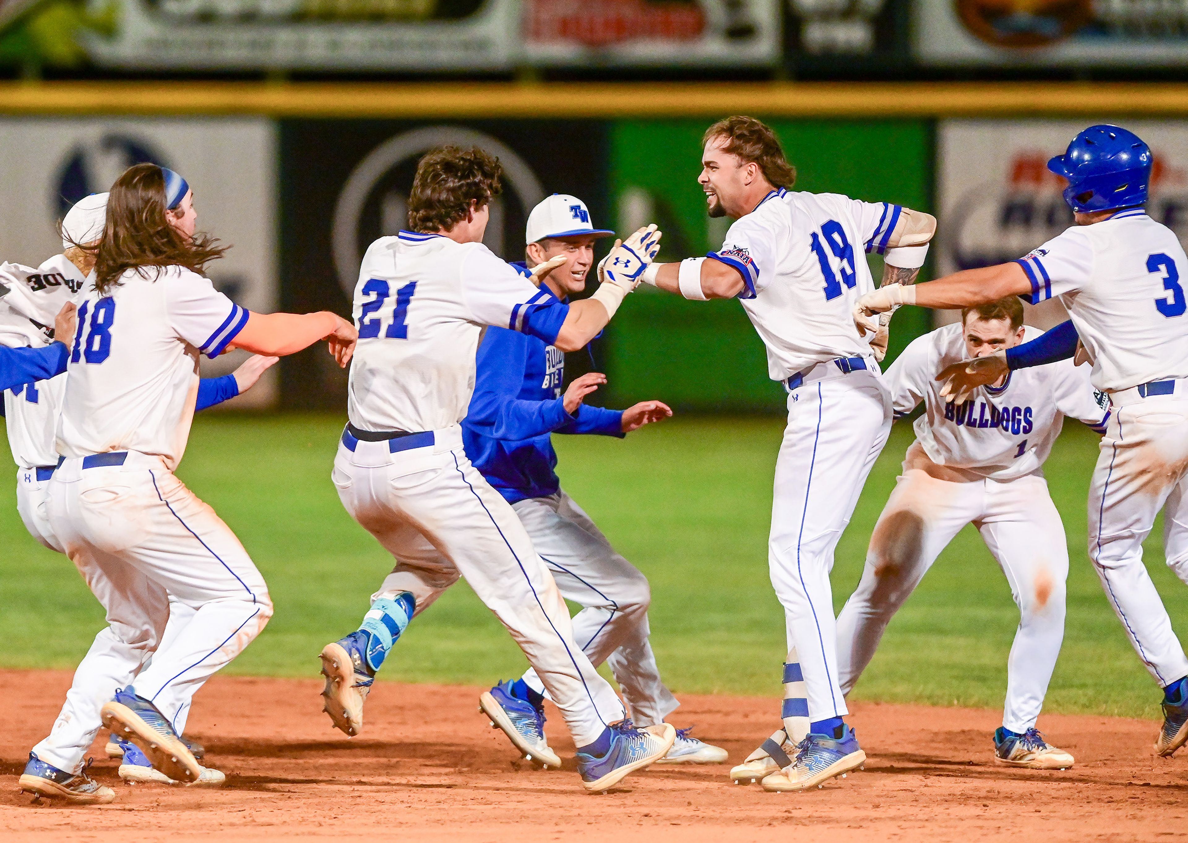 Tennessee Wesleyan surrounds Kruise Newman in the outfield to celebrate his hit that won Game 18 of the NAIA World Series over Reinhardt at Harris Field in Lewiston on Thursday.