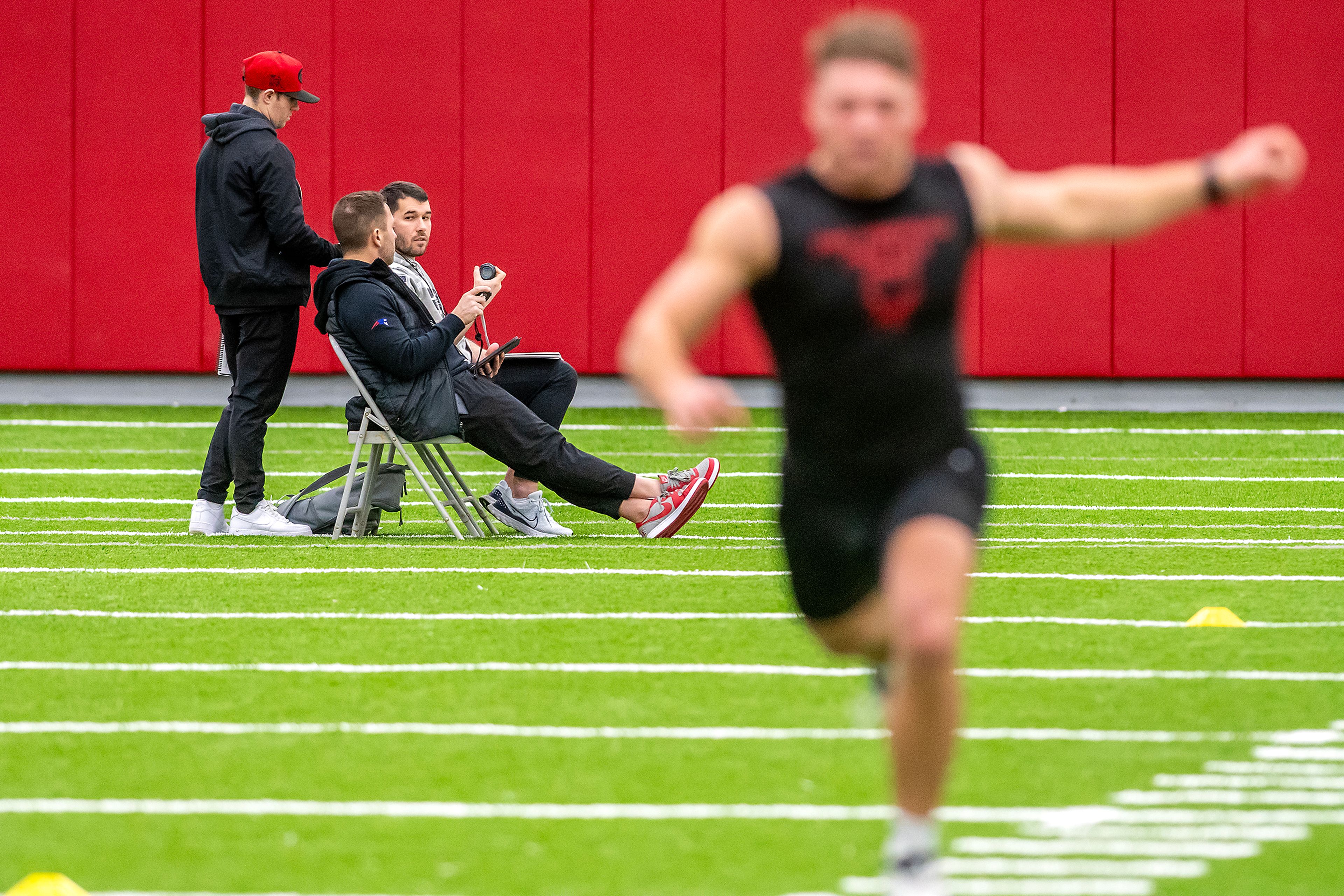 NFL Scouts watch as an Eastern Washington player hits the finish line in the 40-yard dash during WSU's Pro Day on Friday in Pullman.