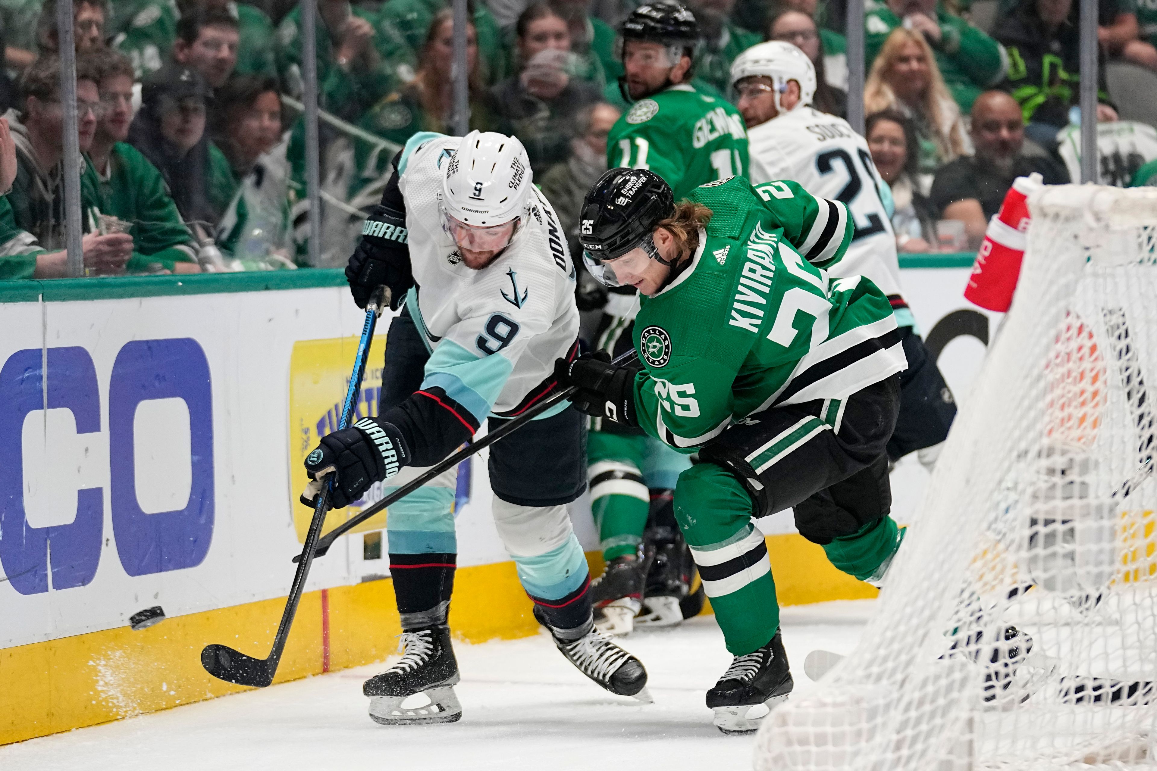 Seattle Kraken center Ryan Donato (9) clears the puck from behind the net under pressure from Dallas Stars left wing Joel Kiviranta (25) in the first period of Game 7 of an NHL hockey Stanley Cup second-round playoff series, Monday, May 15, 2023, in Dallas. (AP Photo/Tony Gutierrez)