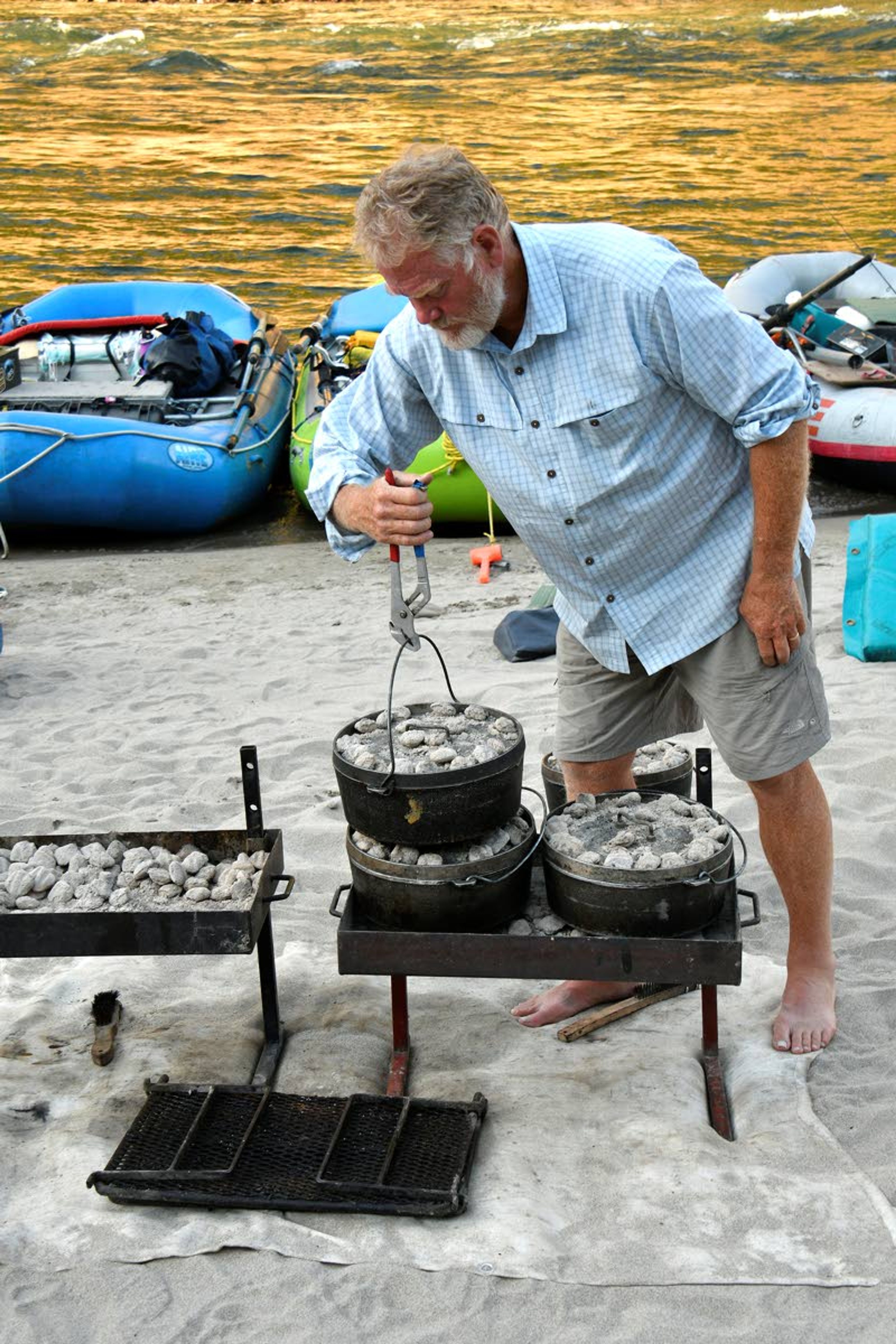 Doug Lawrence cooks up a feast in Dutch ovens during a raft trip from the source of the Salmon River to the sea.