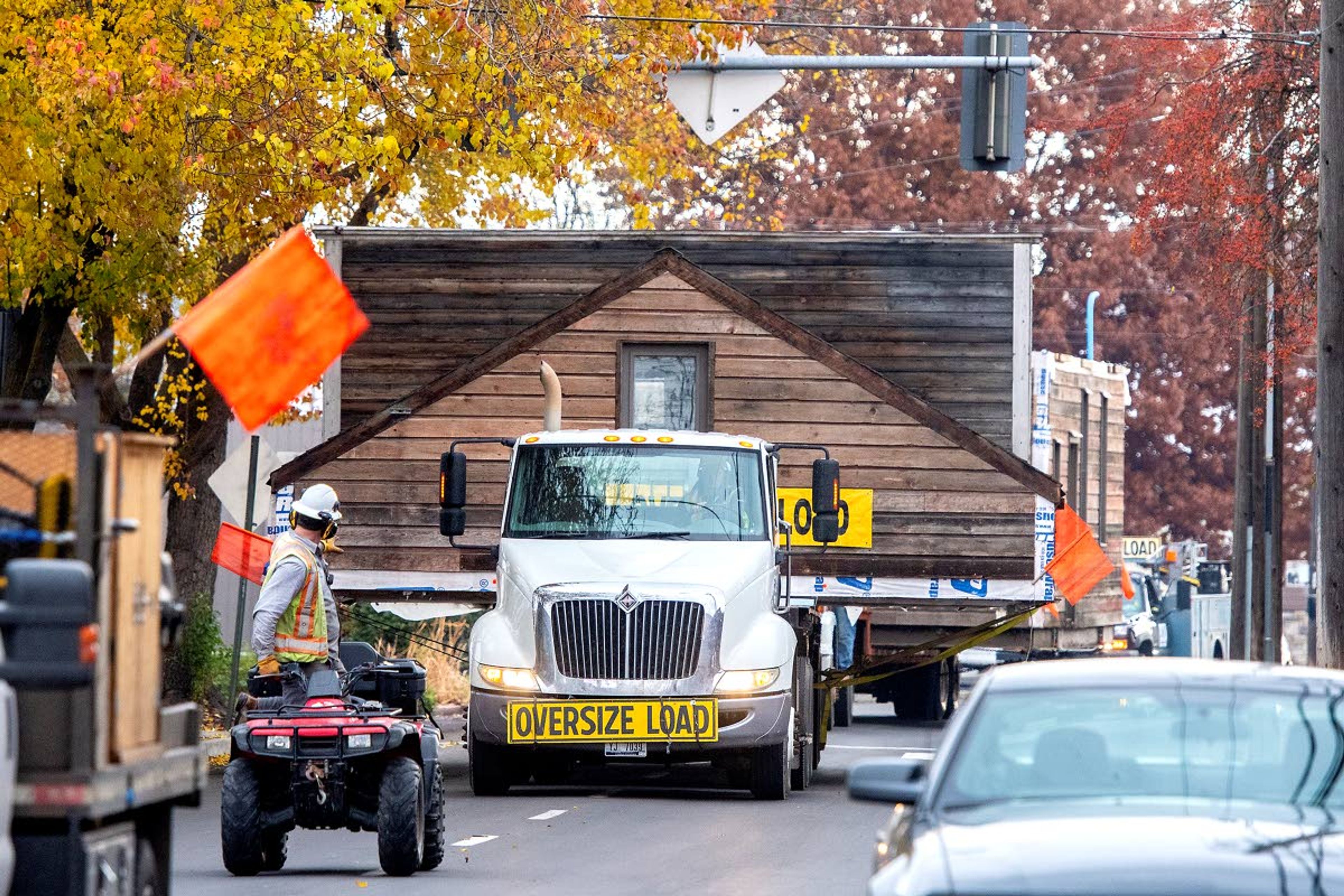 Brian McDermott rides an all-terrain vehicle as he guides the Idaho Territorial Capitol building, divided into two parts, through a tight fit down D Street in Lewiston on Tuesday morning. The replica building was moved from its old location at the intersection of Main and 12th streets to its new location beside the Nez Perce County Historical Society and Museum.