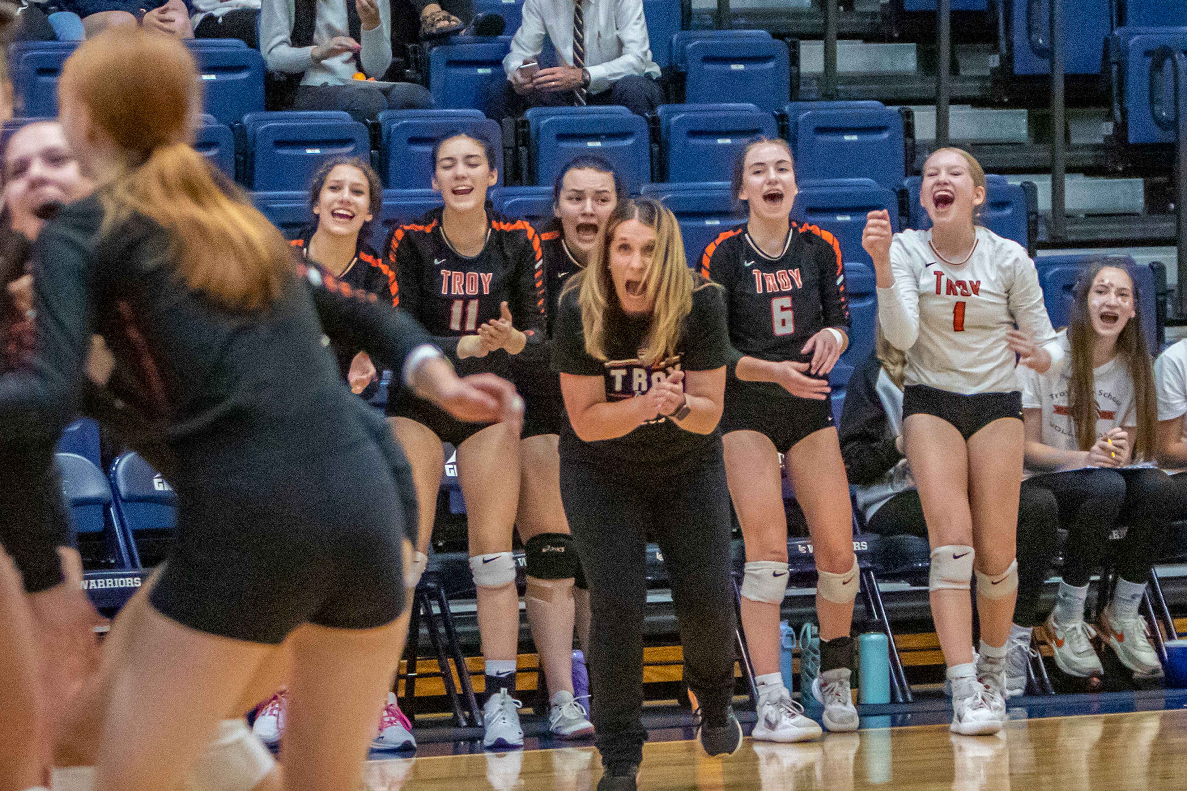 Troy volleyball coach Deborah Blazzard, center, and her players celebrate after scoring a point against Genesse during the Idaho 1A DI district  tournament Oct. 19, 2022 at the P1FCU Activity Center in Lewiston.