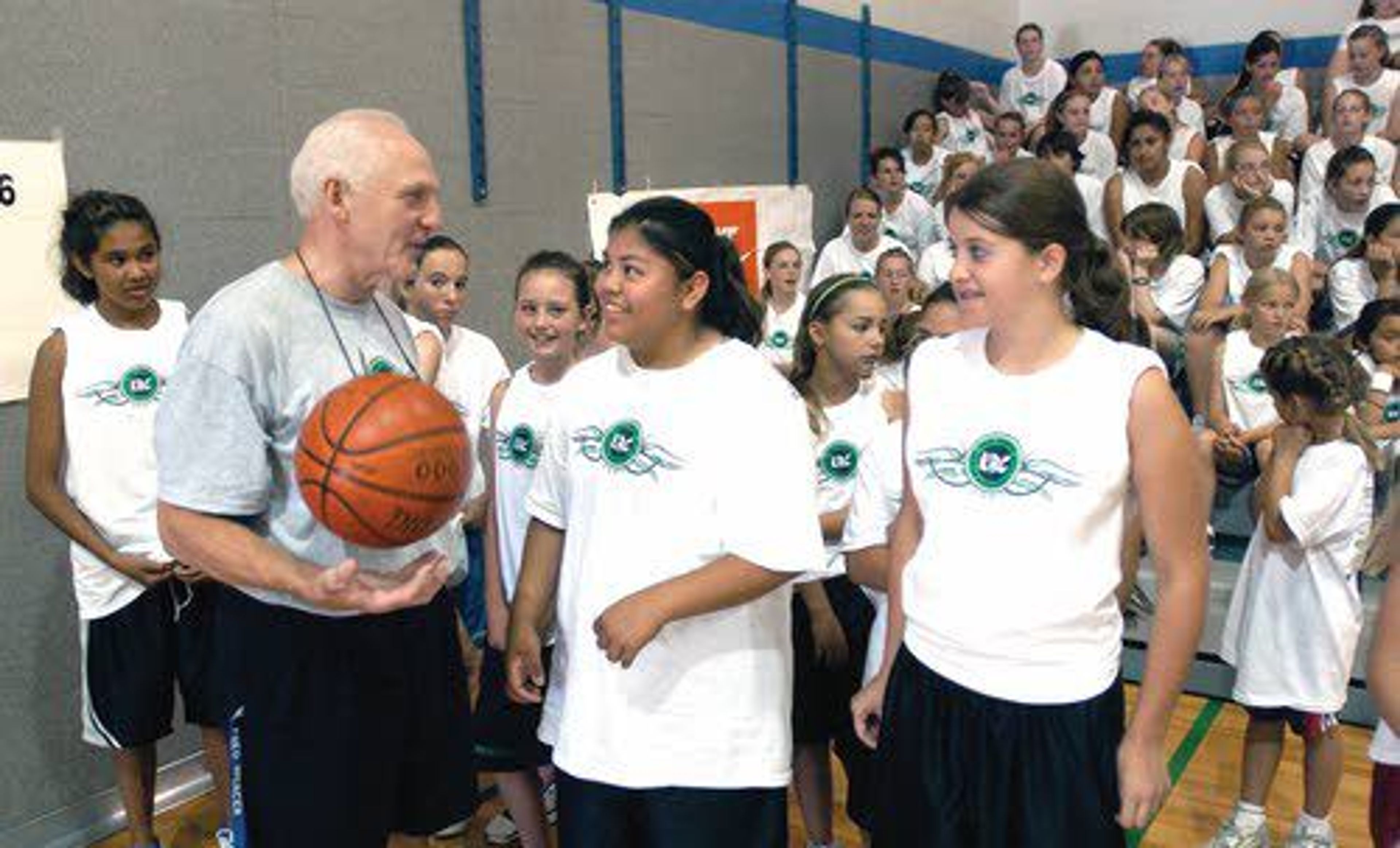 Fred Mercer has a laugh with girl's basketball camp participants a decade ago. Mercer's 40th and final year of camps wraps up this week.