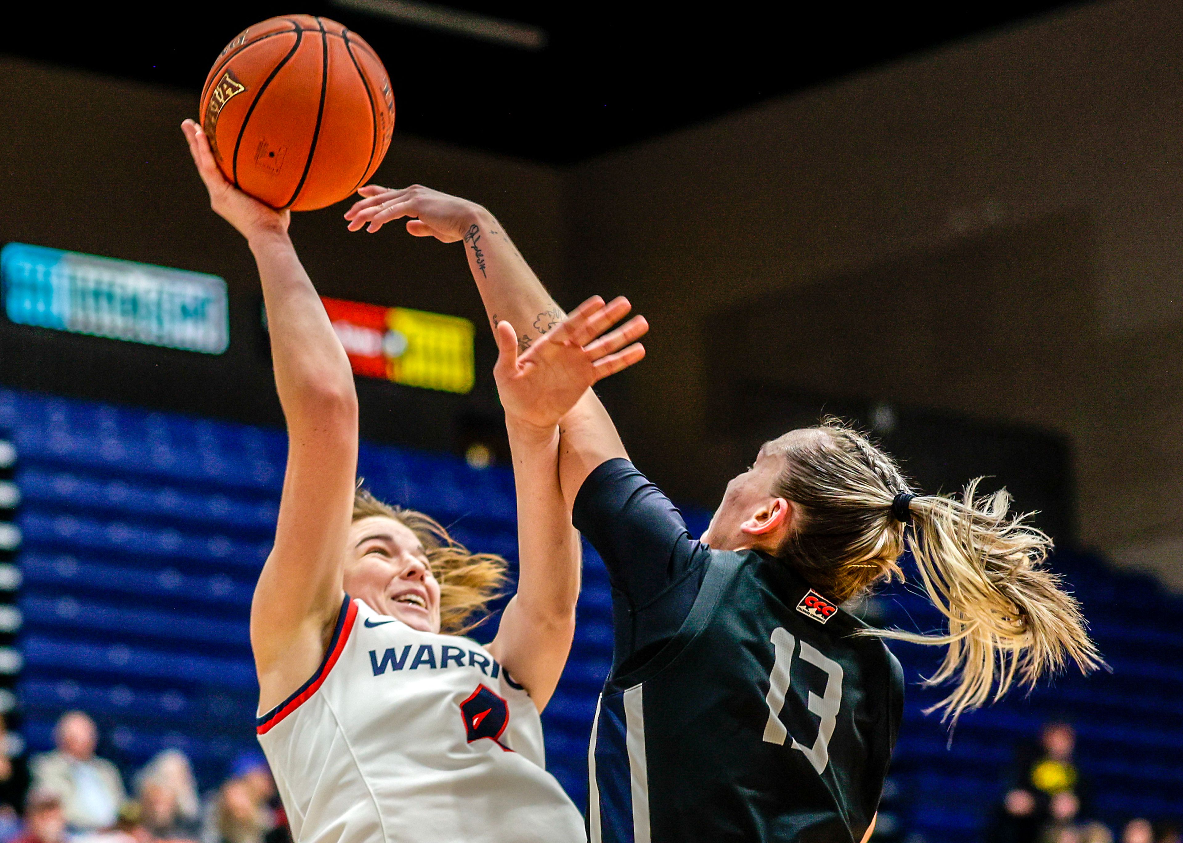 Lewis-Clark State guard Ellie Sander shoots the ball as Eastern Oregon guard Bayley Brennan defends during a Cascade Conference game Friday at Lewis-Clark State College.