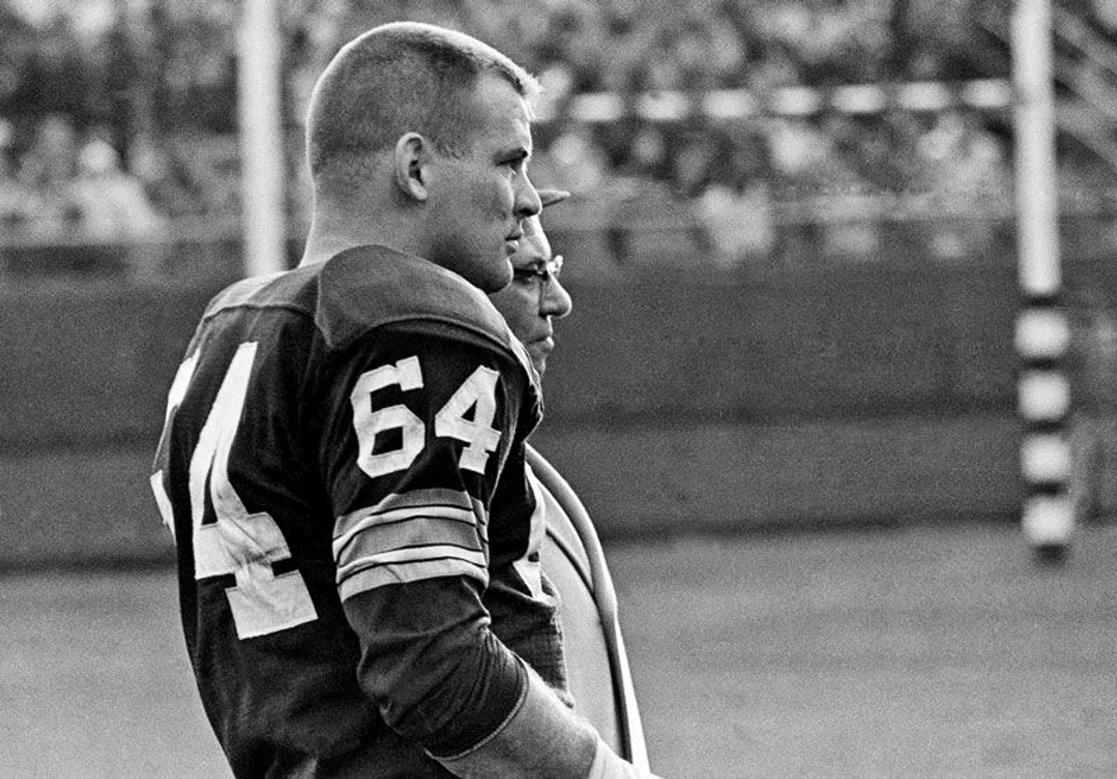 In this Nov. 24, 1963, file photo, Green Bay Packers offensive guard Jerry Kramer and coach Vince Lombardi watch the Packers' defense against the San Francisco 49ers in an NFL football game in Milwaukee. Kramer was elected to the Pro Football Hall of Fame on Saturday, Feb. 3, 2018. (AP Photo/File)