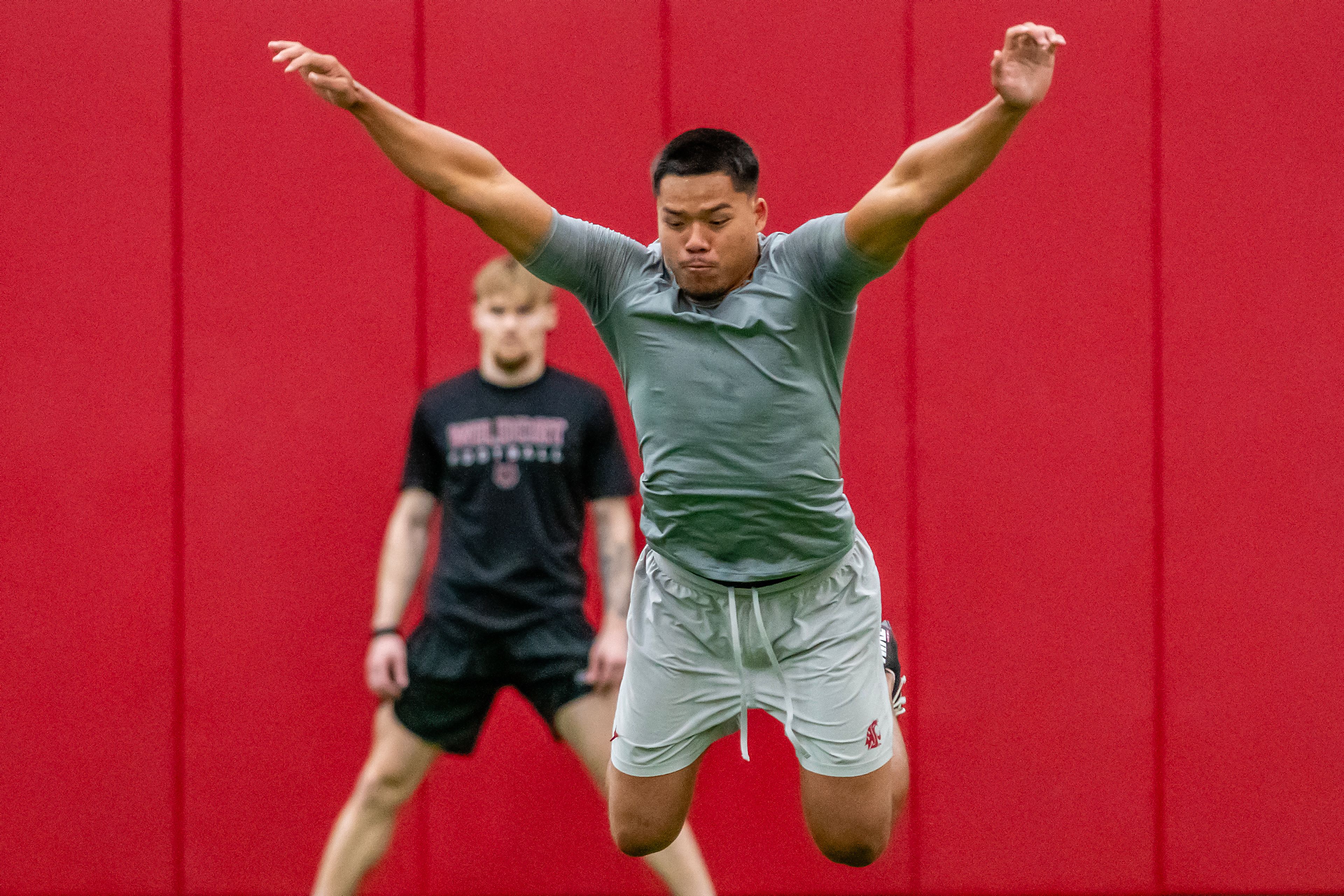Washington State safety Tanner Moku leaps forward in the broad jump test during WSU's Pro Day on Friday in Pullman.