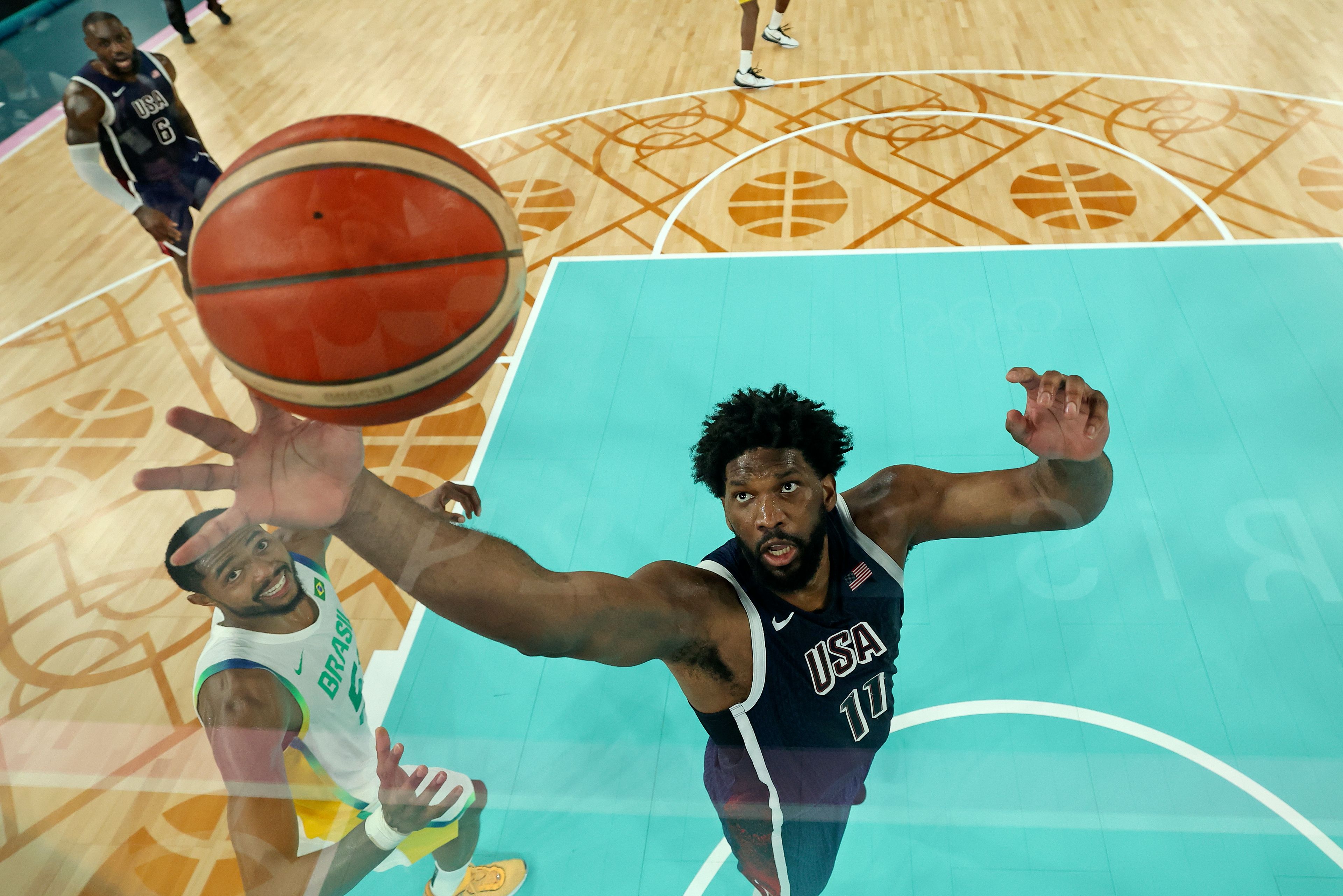 United States' Joel Embiid reaches for the ball during a men's quarterfinal game at Bercy Arena at the 2024 Summer Olympics, Tuesday, Aug. 6, 2024, in Paris, France. (Jamie Squire/Pool Photo via AP)