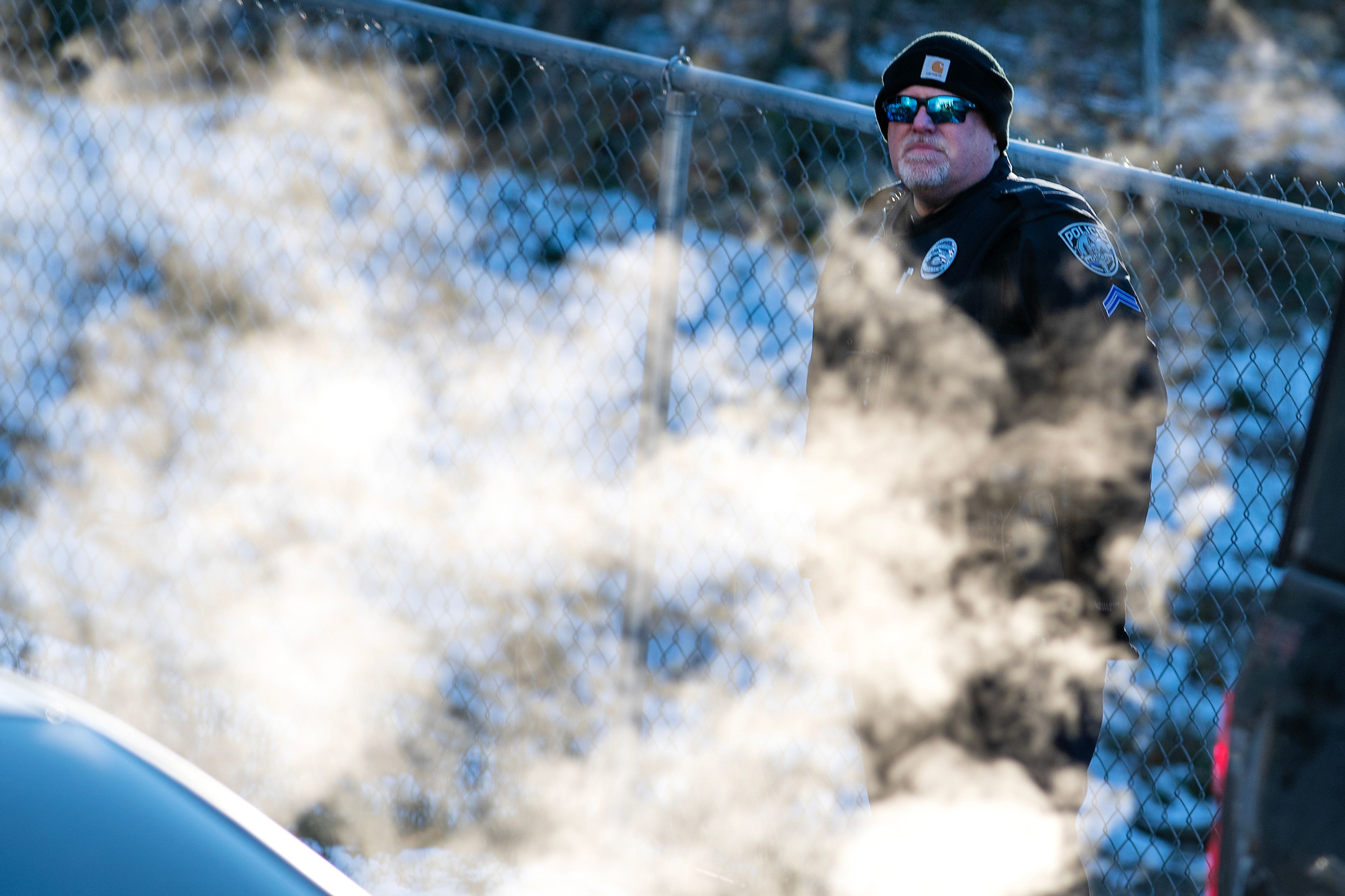 Exhaust fumes surround an officer patrolling the crime scene where four University of Idaho students were murdered in an off-campus home in Moscow.