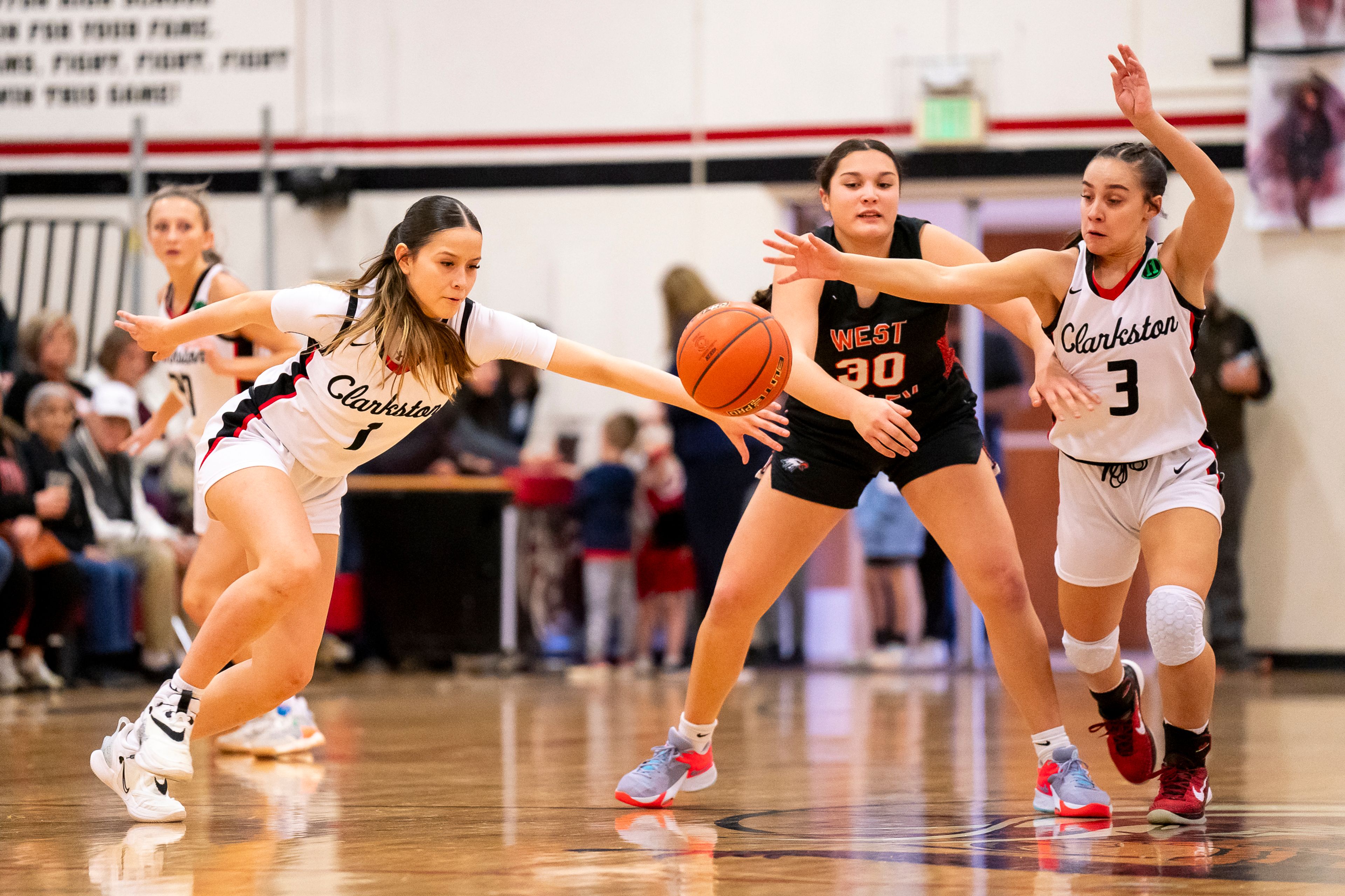 Clarkston’s Jaelyn Marks (1) and Kendall Wallace (3) go after a loose ball during a girls 2A district championship game against West Valley on Feb. 17 at Clarkston High School.