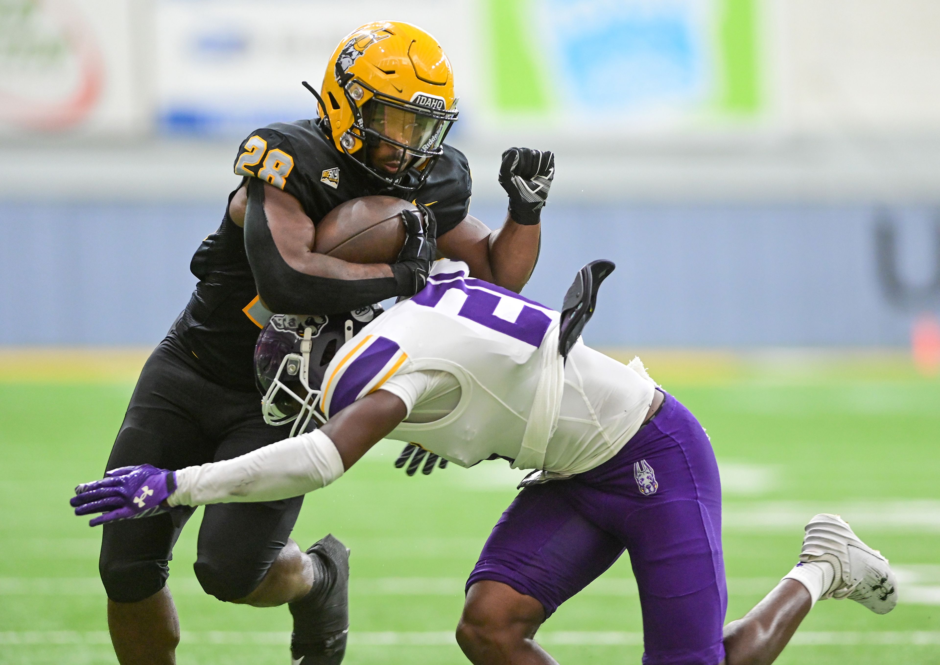 Idaho Vandals running back Nate Thomas (28) is tackled after completing a pass Saturday during a game against Albany Great Danes at the P1FCU Kibbie Dome in Moscow.,