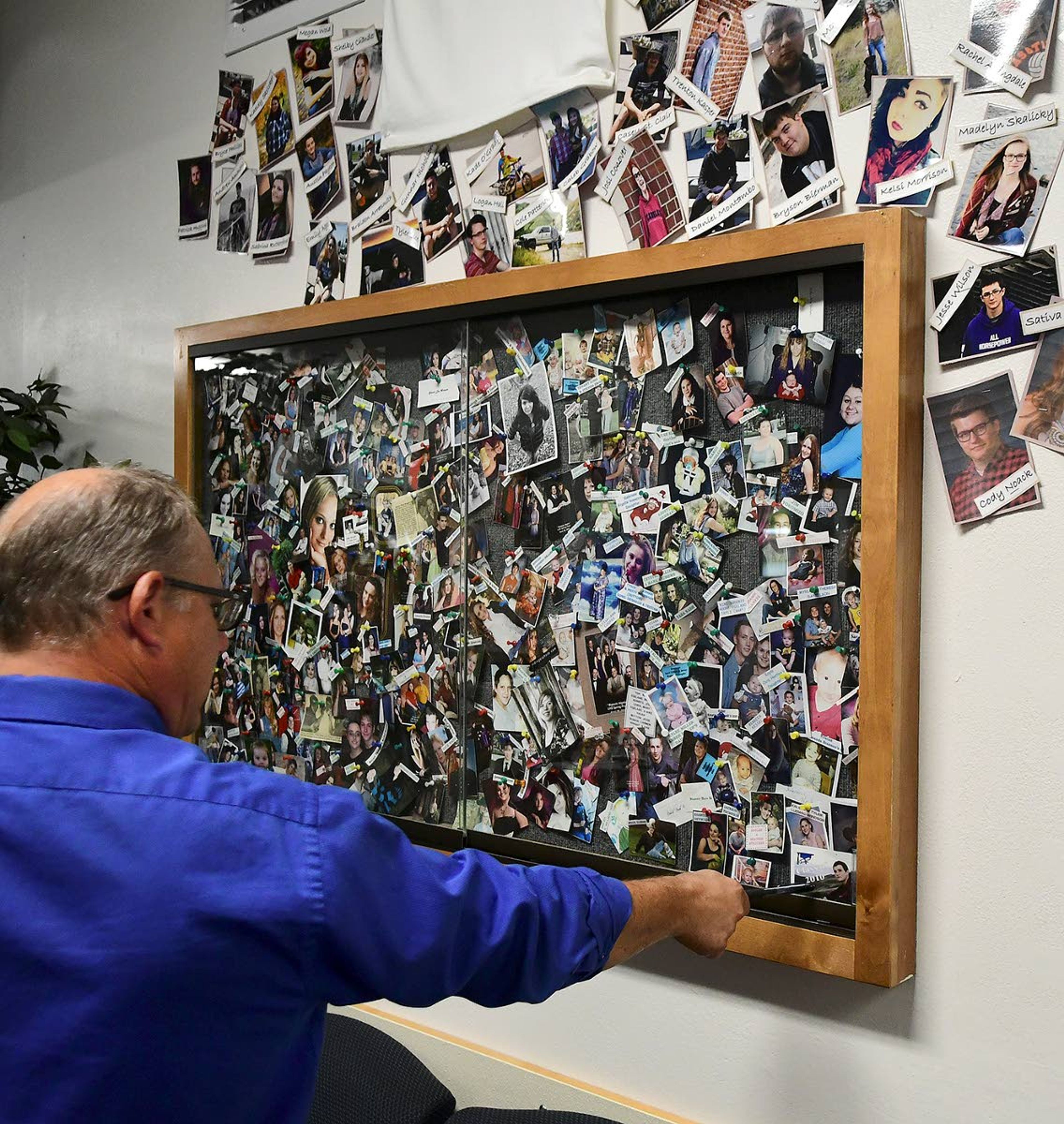 Tammany High School Principal Greg Kramasz surveys a photo display of some the approximatey 1,000 graduates of the school.