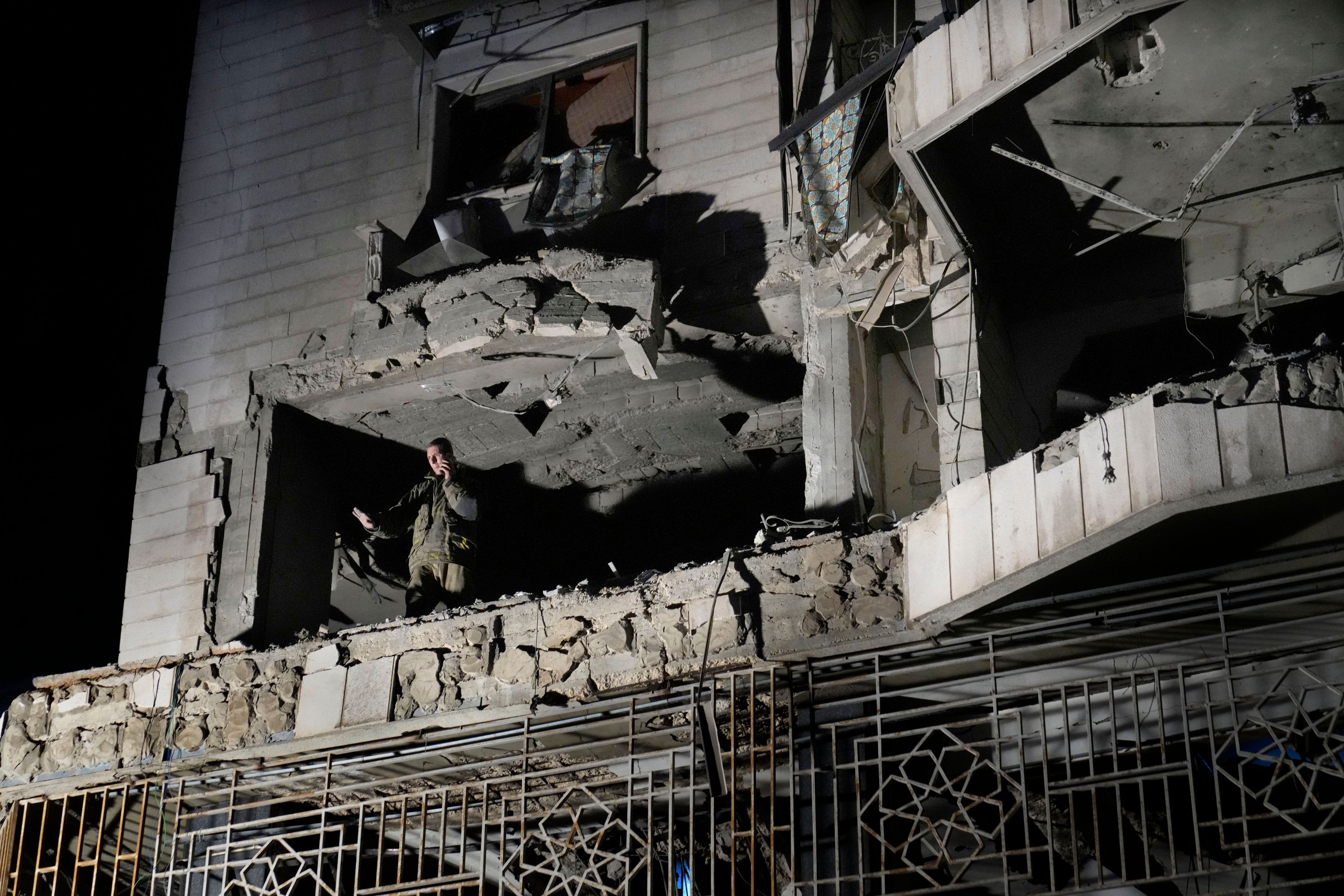 A rescue worker surveys an apartment building hit by an airstrike in Beirut, Lebanon, Thursday, Oct. 3, 2024. (AP Photo/Hussein Malla)