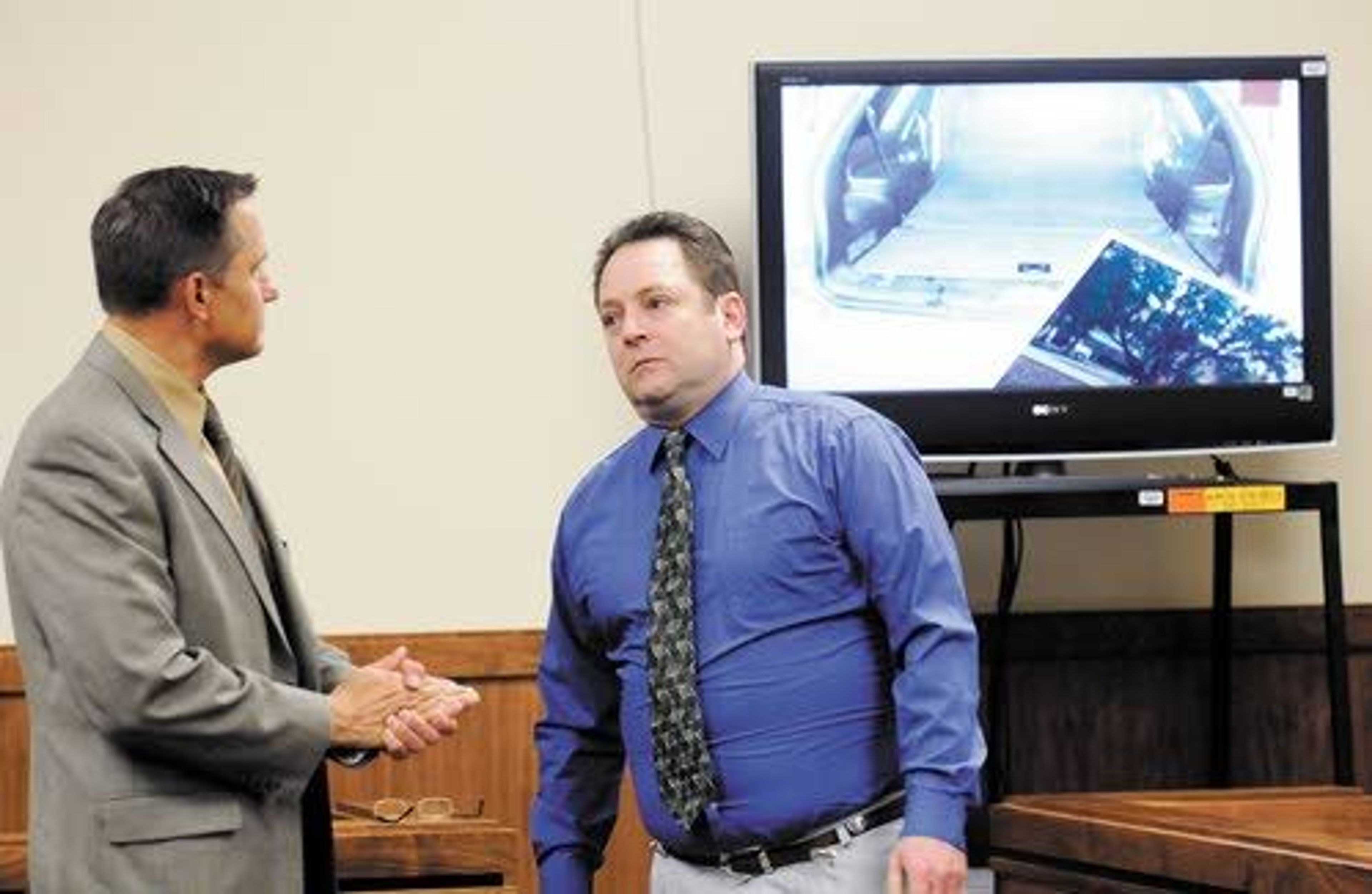 Latah County Sheriff’s Cpl. Tim Besst talks with David C. Stone during a break Tuesday in the Charles A. Capone trial on murder charges in Moscow. A picture of Stone’s Dodge Durango can be seen in the backgorund.