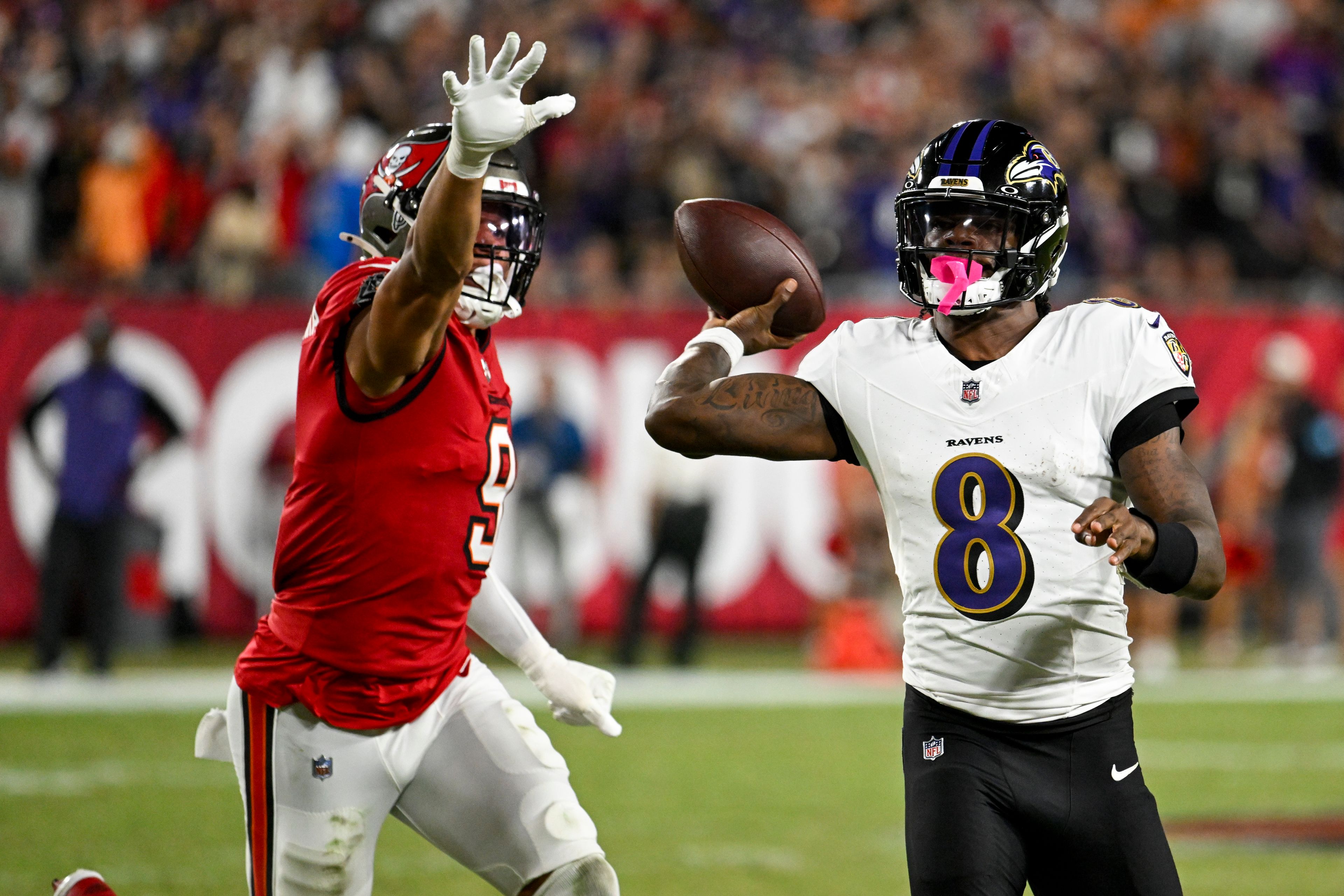 Baltimore Ravens quarterback Lamar Jackson (8) is pressured by Tampa Bay Buccaneers linebacker Joe Tryon-Shoyinka (9) during the first half of an NFL football game, Monday, Oct. 21, 2024, in Tampa, Fla. (AP Photo/Jason Behnken)