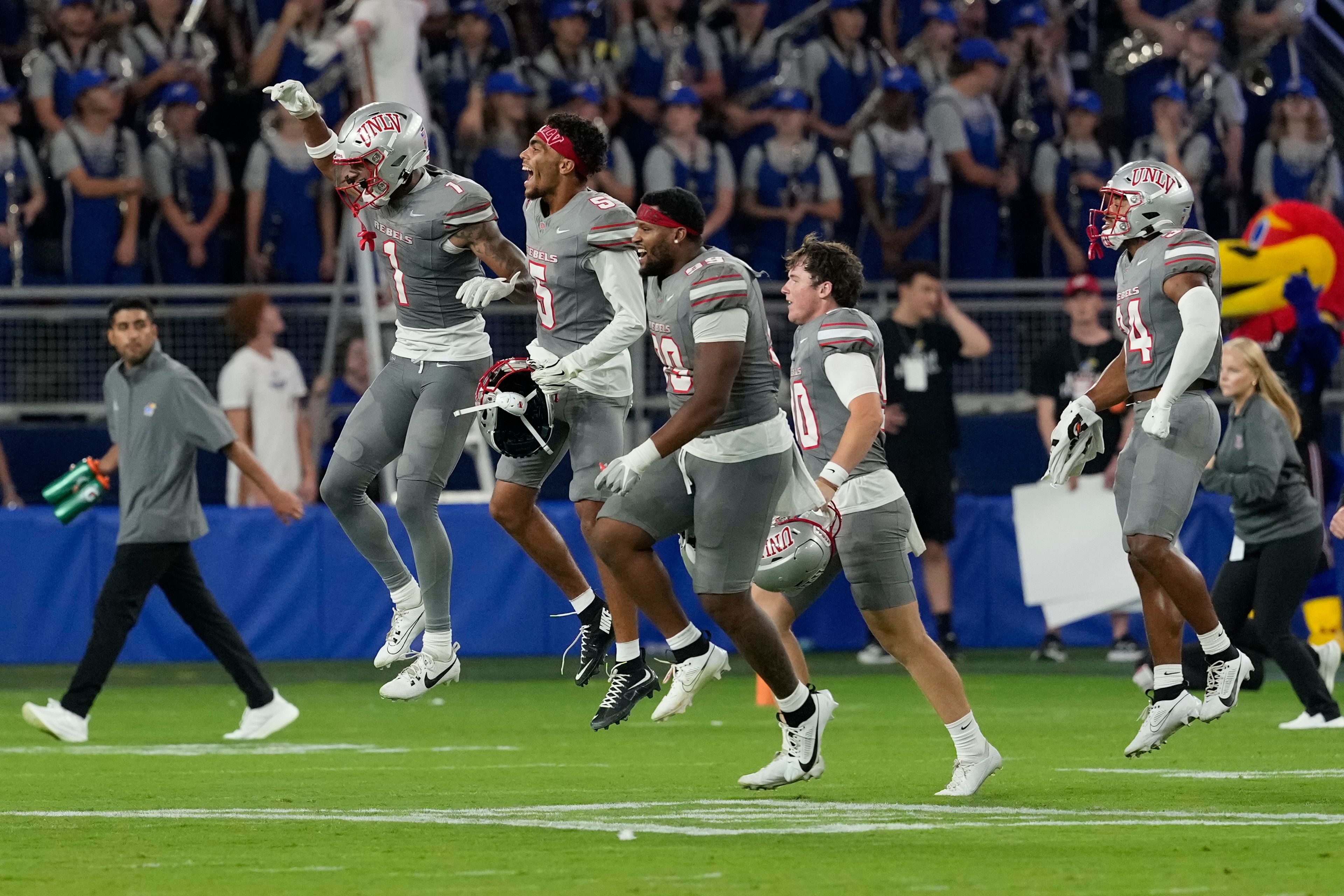 Members of UNLV run onto the field after a 23-20 win over Kansas during an NCAA college football game, Friday, Sept. 13, 2024, at Children's Mercy Park in Kansas City, Kan. (AP Photo/Ed Zurga)