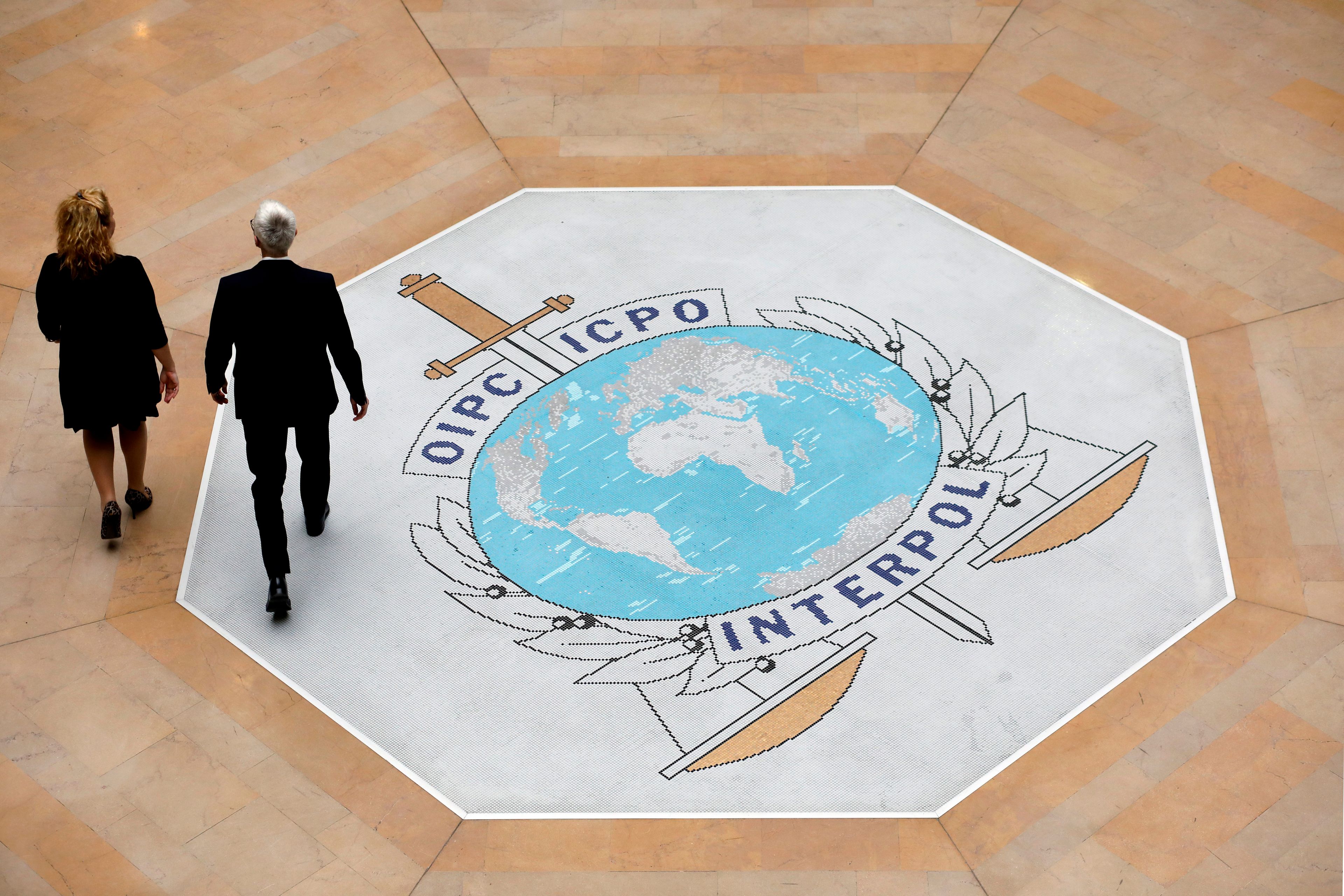 FILE - People walk on the Interpol logo at the international police agency headquarters in Lyon, central France, Thursday Nov. 8, 2018. Interpol said Tuesday, June 4, 2024, it has carried out an anti-corruption operation in the eastern European country of Moldova targeting attempts to sabotage its Red Notice system. The international policing agency, headquartered in Lyon, France, issued a communique stating the move followed the detection of a “small number” of attempts to “block and delete” Red Notices, a critical tool that flags fugitives to law enforcement worldwide.