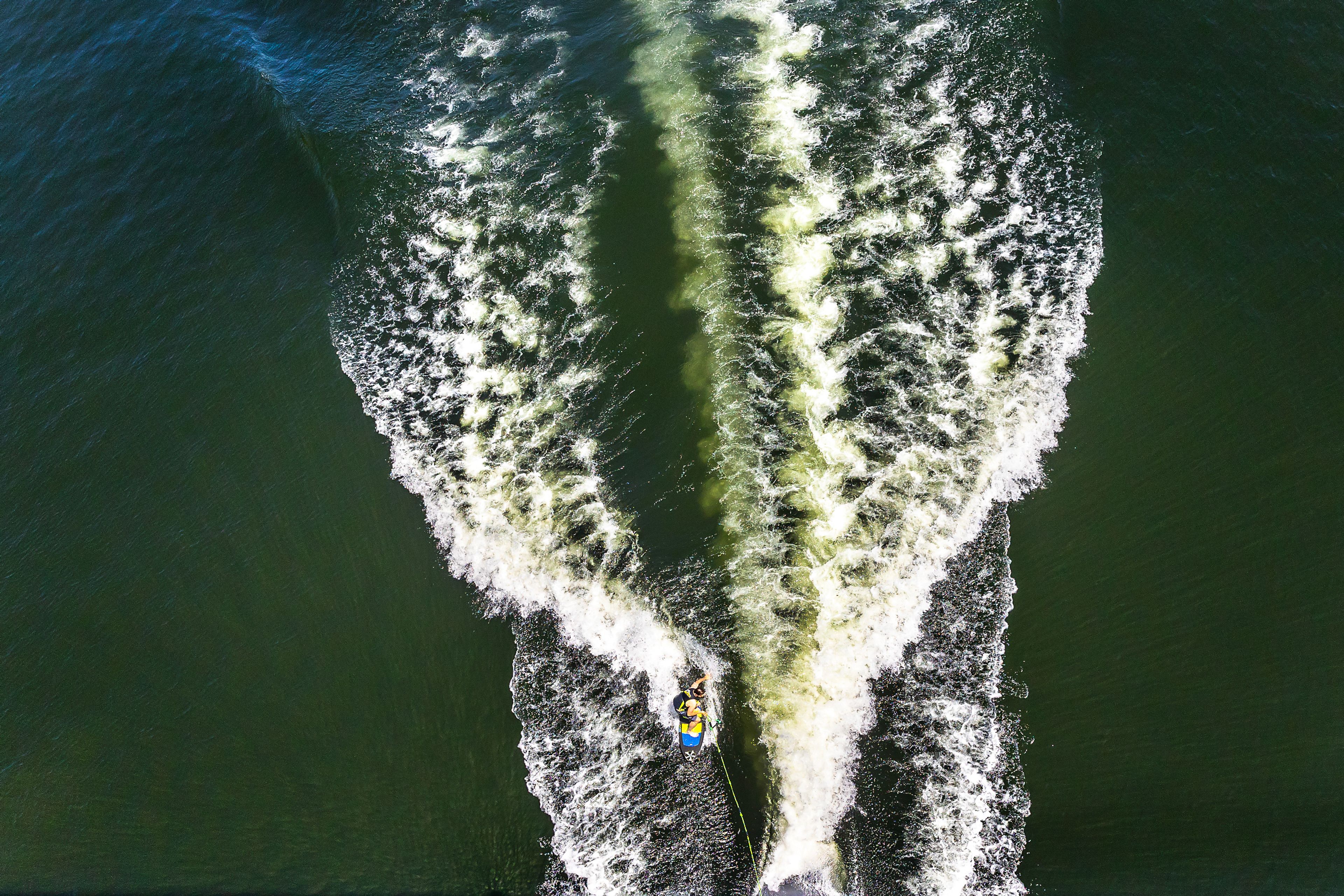 A wake boarder surfs behind a boat as it passes under the Southway Bridge Tuesday on the Snake River.