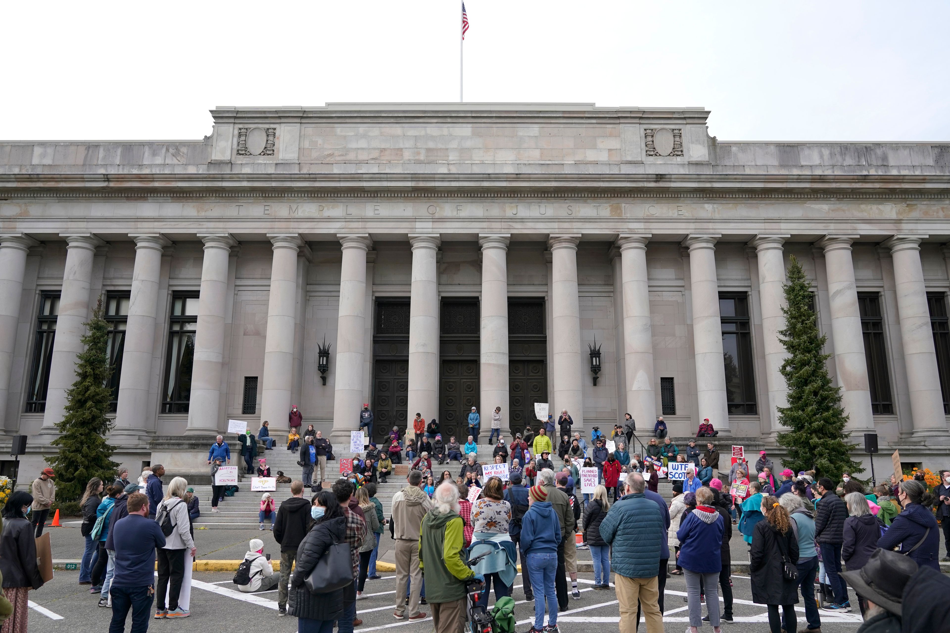 People demonstrating in favor of abortion rights gather in front of the Temple of Justice, which houses the Washington state Supreme Court, during an evening rally, Tuesday, May 3, 2022, at the Capitol in Olympia, Wash. (AP Photo/Ted S. Warren)