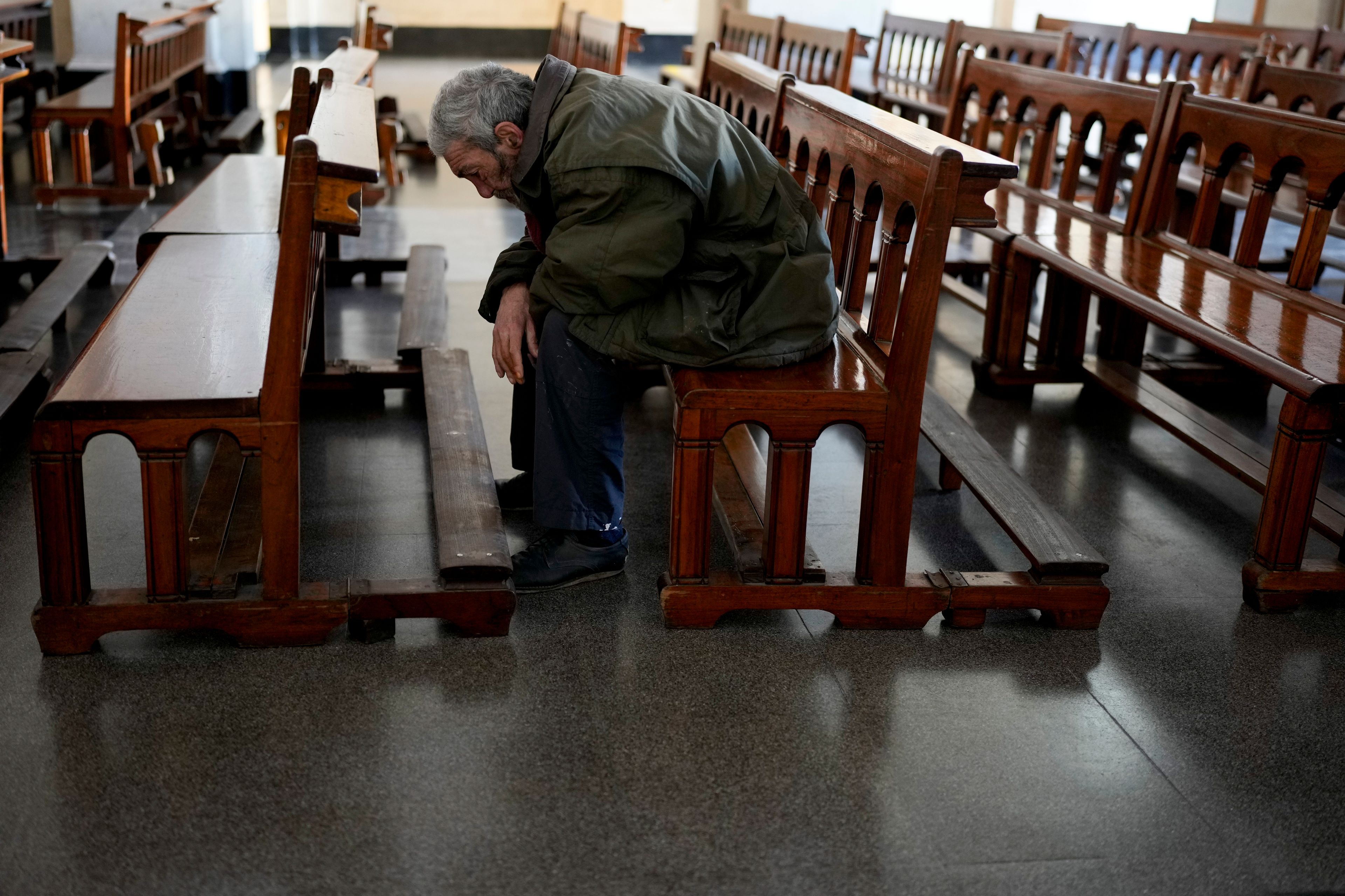 Eduardo Escoz prays at a church on the outskirts of Buenos Aires, Argentina, Thursday, Sept. 12, 2024. Escoz said he pays about $50 a month for a room that he shares with two other people. (AP Photo/Natacha Pisarenko)