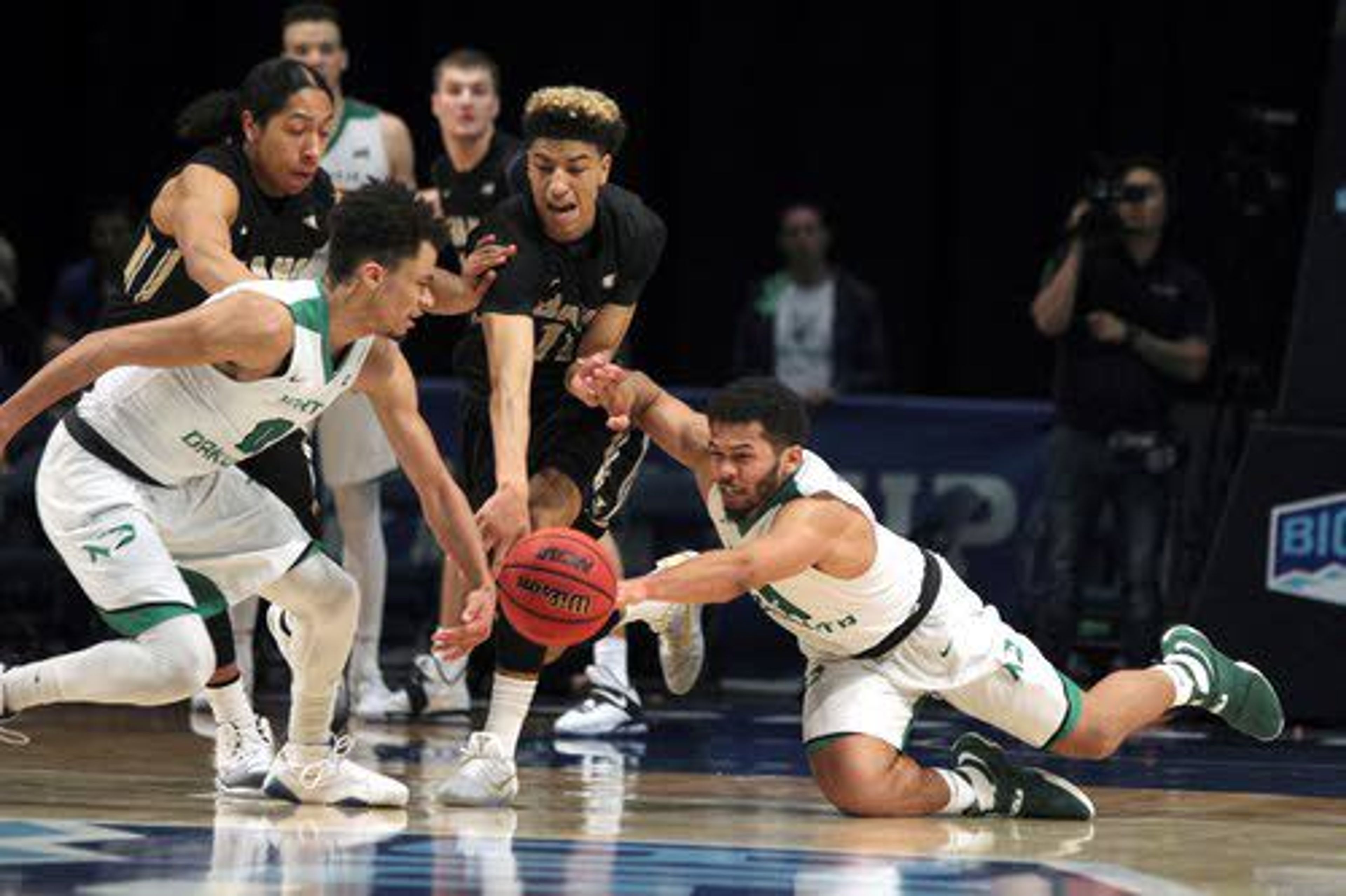 Idaho players Trevon Allen (left) and Victor Sanders scramble for possession against Geno Crandall (0) and Quinton Hooker (right). North Dakota downed the Vandals 69-64 on Friday night in the semifinals of the Big Sky tournament at Reno, Nev.