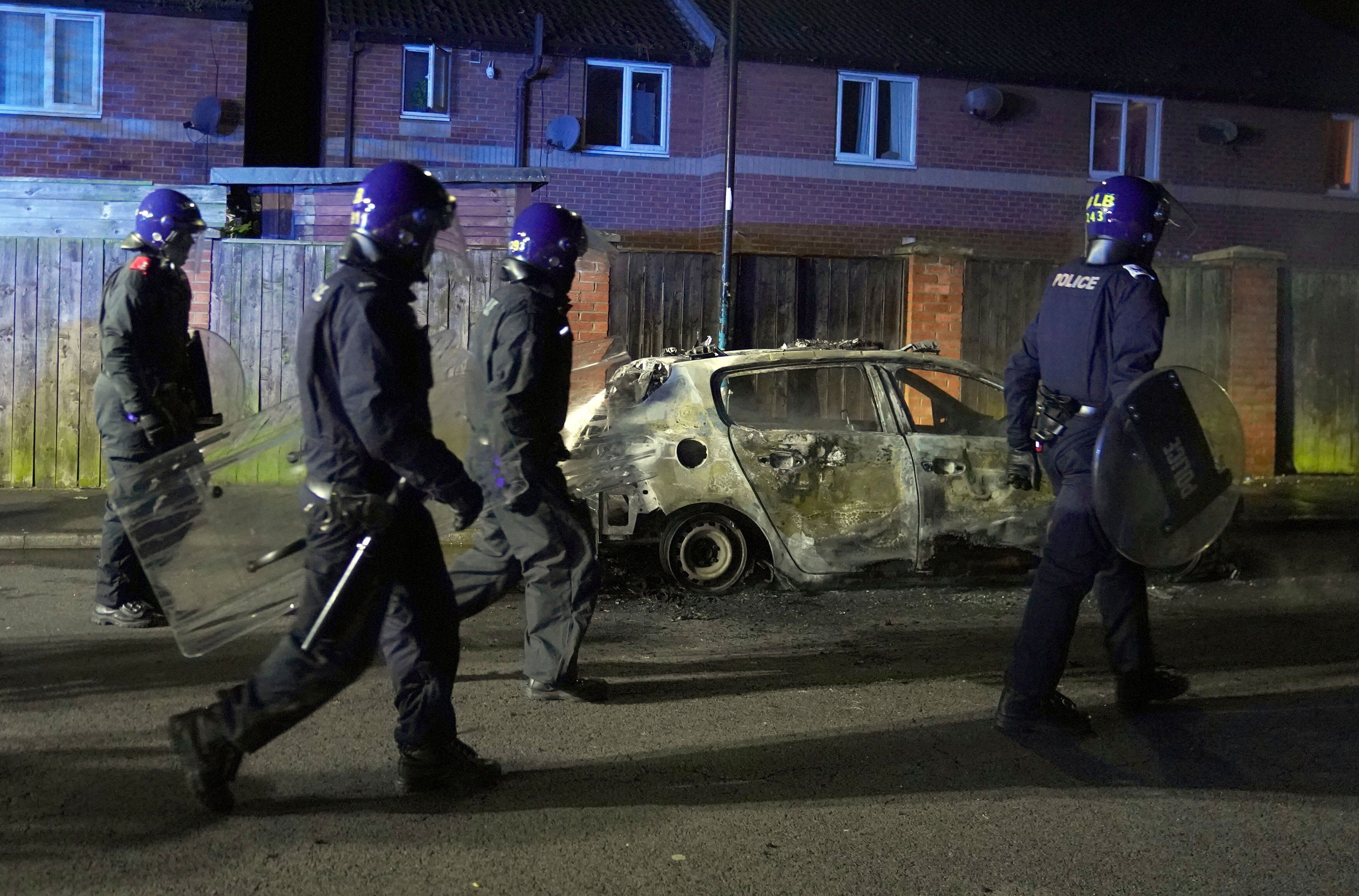 Police Officers walk past a burnt out police vehicle as they are deployed on the streets of Hartlepool, England, following a violent protest in the wake of the killing of three girls who were fatally stabbed in northwest England, Wednesday, July 31, 2024. Far-right groups seek to stir anger over an attack they have sought to link â€” without evidence â€” to immigrants. (Owen Humphreys/PA via AP)