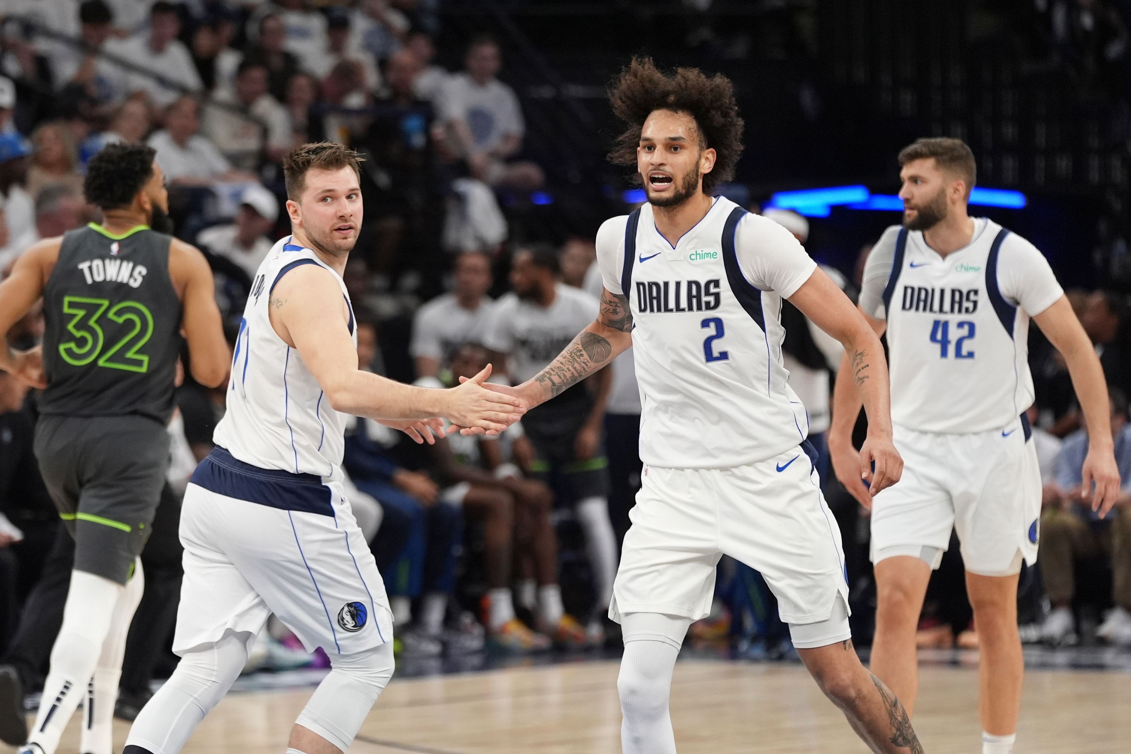 Mavericks center Dereck Lively II, center, slaps hands with Mavericks guard Luka Doncic, second from left, after Doncic's score against the Timberwolves during the first half of Game 5 of the Western Conference finals in the NBA playoffs Thursday in Minneapolis.