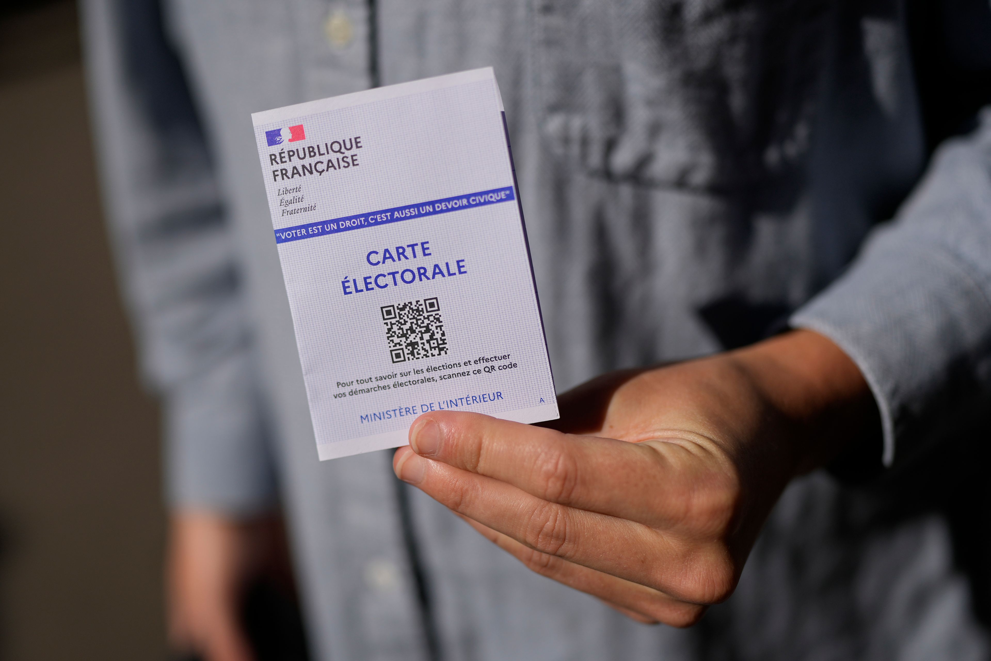 A man shows his voting card in a voting station during the European election, Sunday, June 9, 2024 in Paris. Polling stations opened across Europe on Sunday as voters from 20 countries cast ballots in elections that are expected to shift the European Union's parliament to the right and could reshape the future direction of the world's biggest trading bloc.