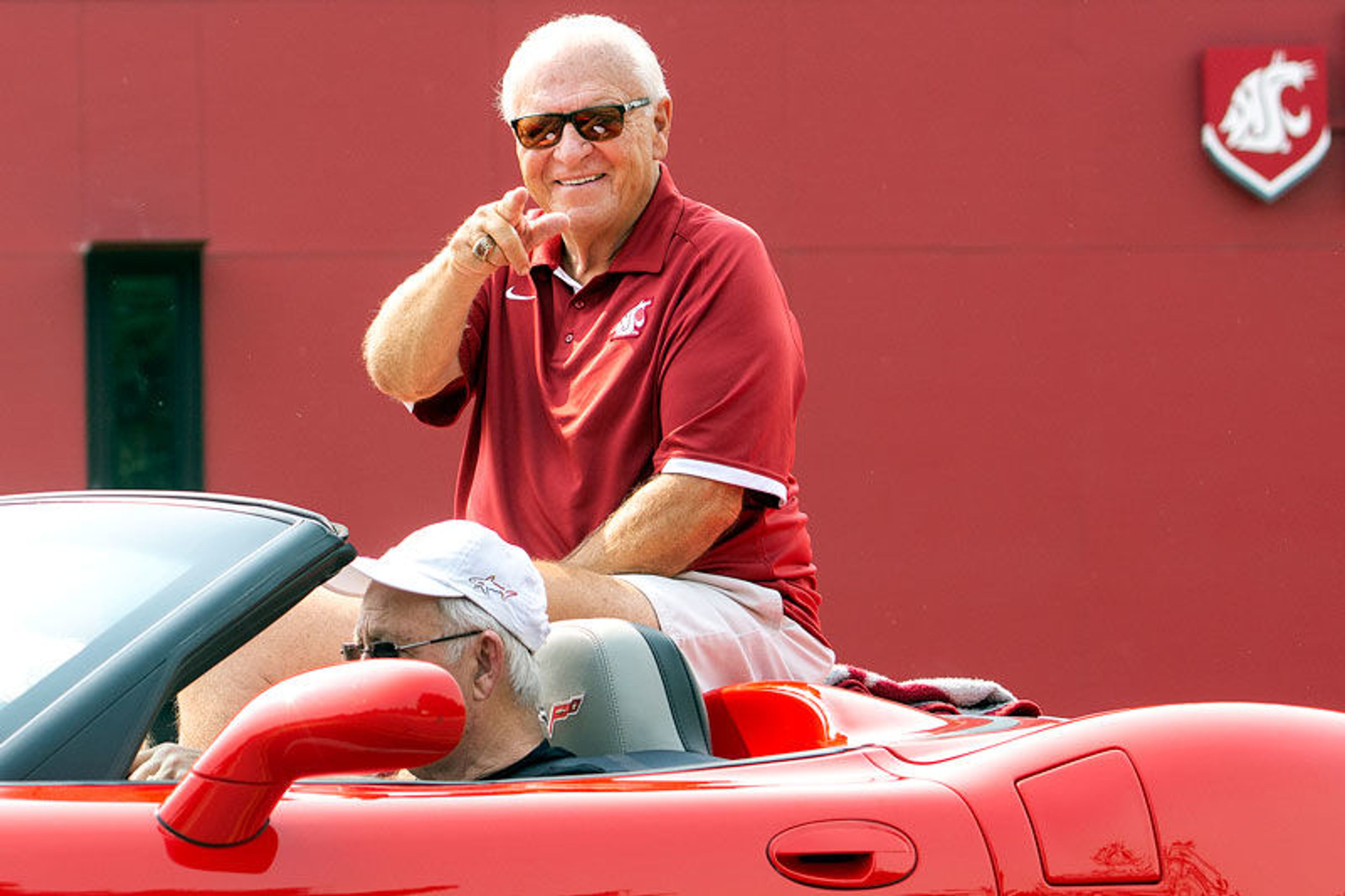 Former Washington State head football coach Mike Price points to the crowd during the National Lentil Festival parade on Saturday in Pullman. Earlier in the day, Price was inducted into the Pullman Walk of Fame.