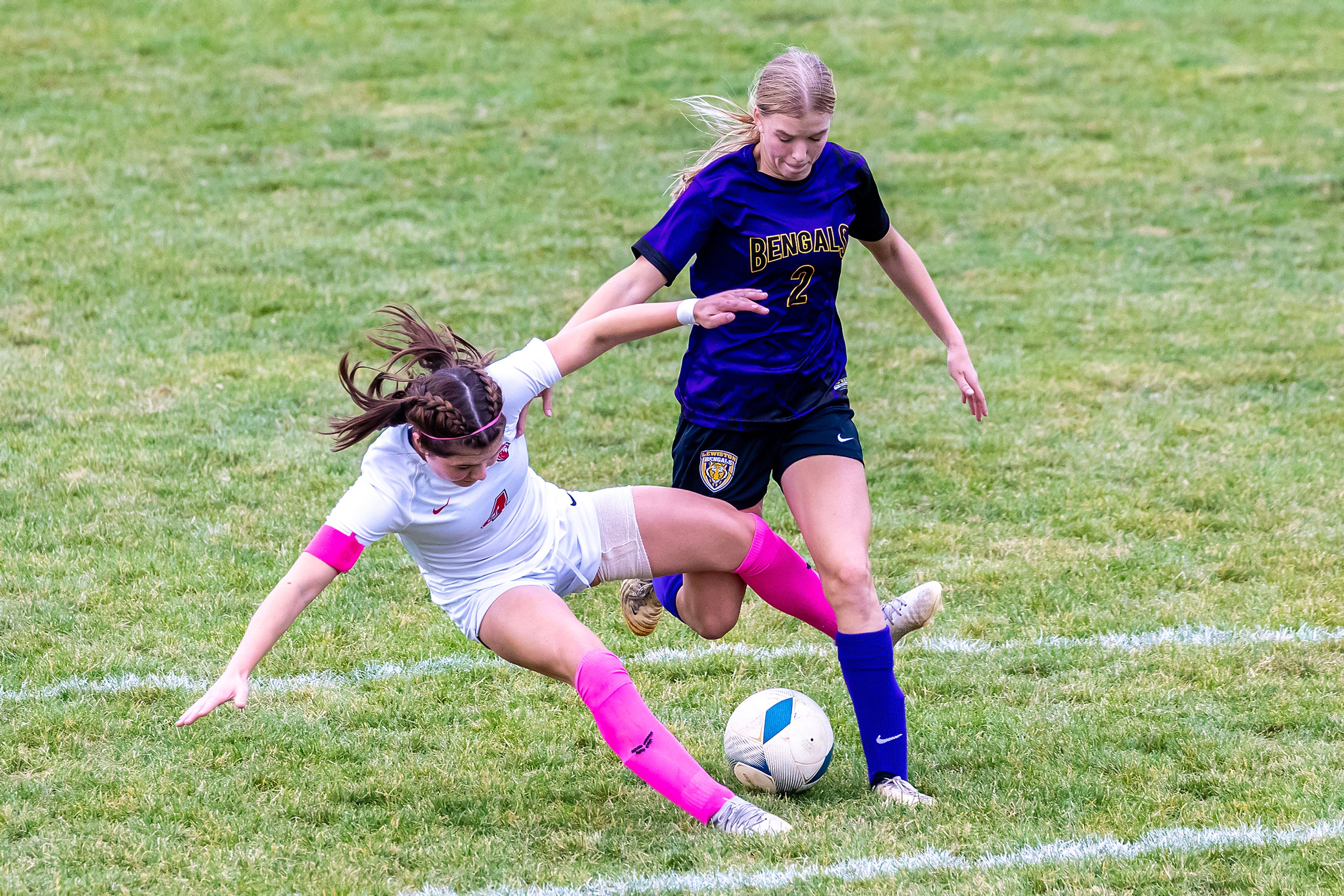 Sandpoint�s Maddie Mitchell gets tripped up between the legs of Lewiston�s Avery Lathen in the 5A Inland Empire League District Championship Wednesday at Walker Field in Lewiston.,