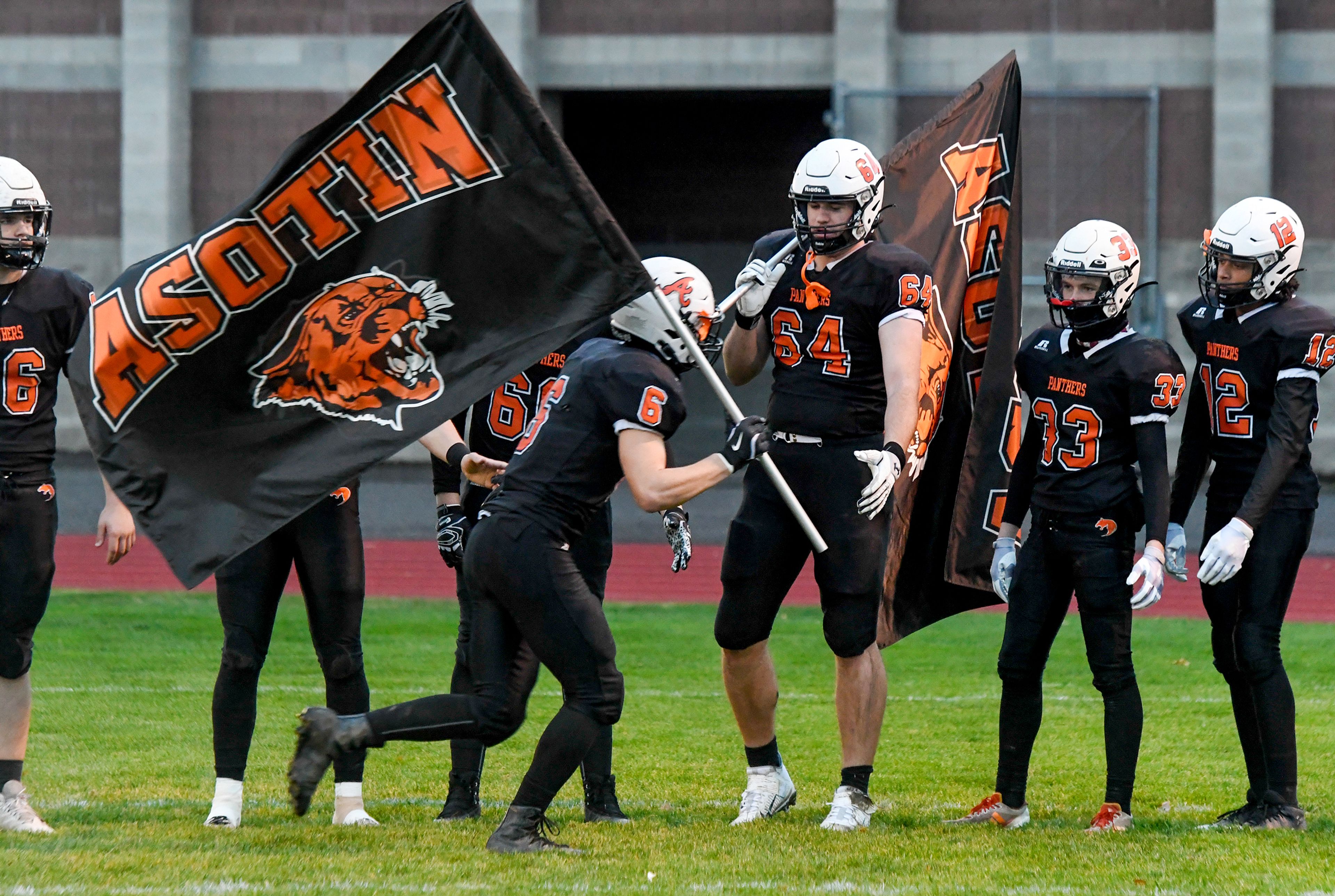 Asotin’s Peter Eggleston and AJ Olerich carry flags during the player introductions Saturday before a Washington 2B state tournament game against La Salle in Clarkston.