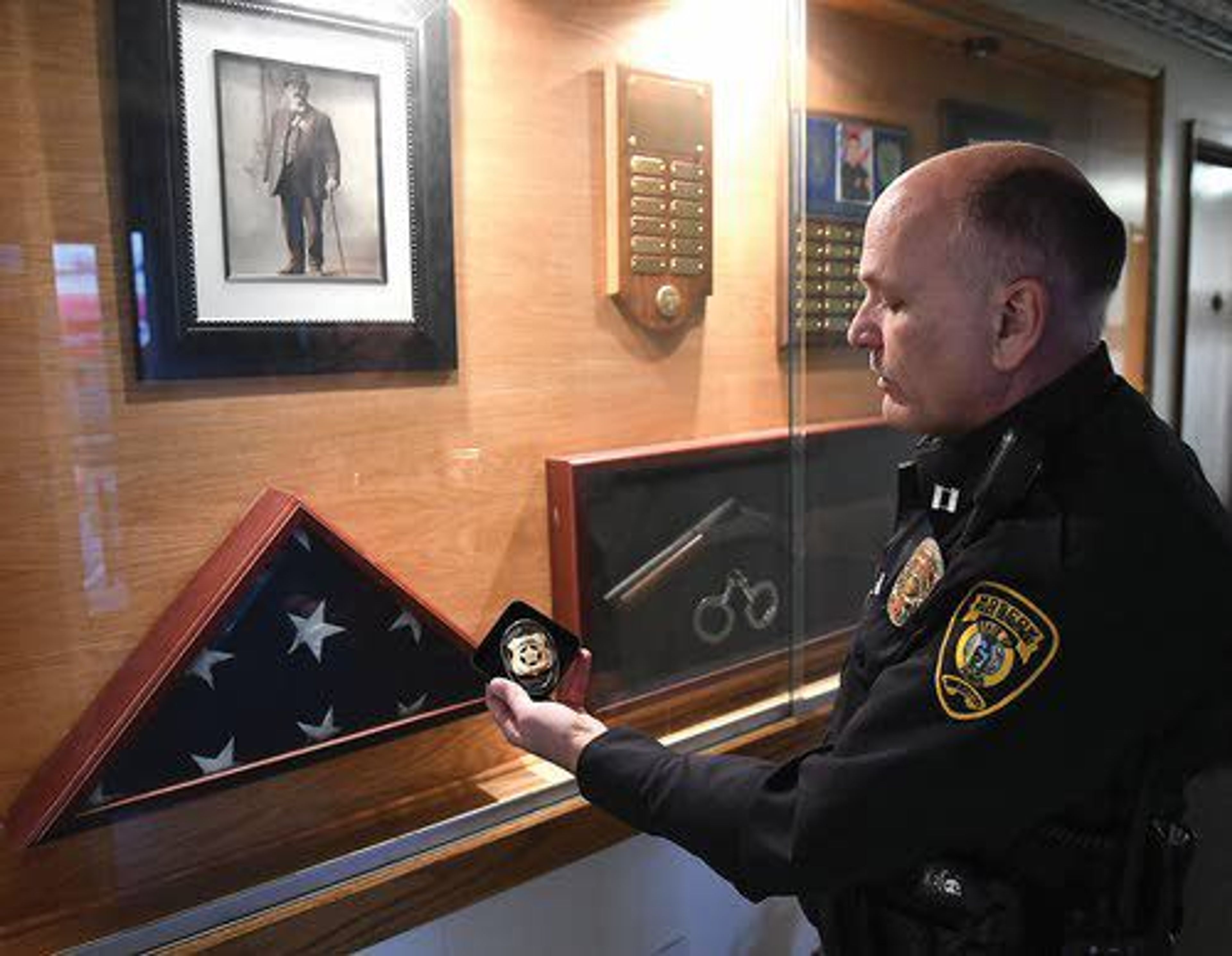 Moscow police Capt. Roger Lanier explains how the commemorative 125th anniversary shield was patterned off of the one worn by Chief William Blacker, pictured in the display case.