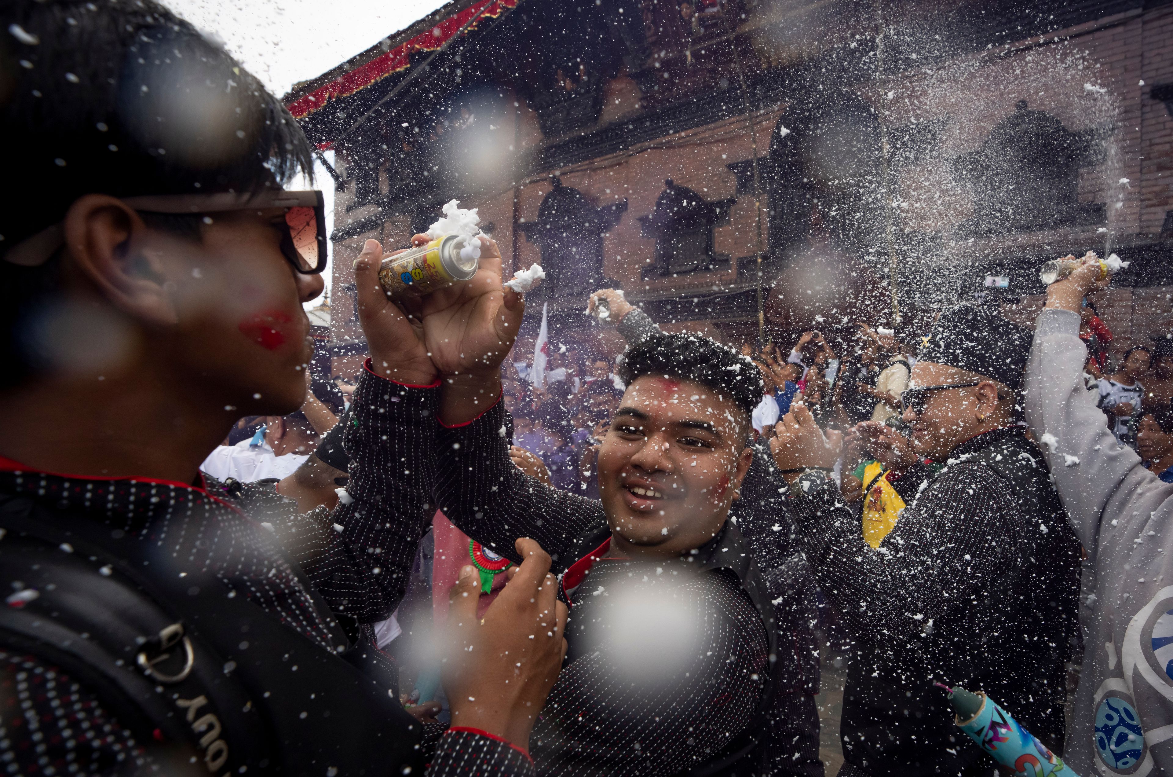 Devotees use foam spray as they dance during Indra Jatra, a festival that marks the end of the rainy season in Kathmandu, Nepal, Tuesday, Sept. 17, 2024. (AP Photo/Niranjan Shrestha)