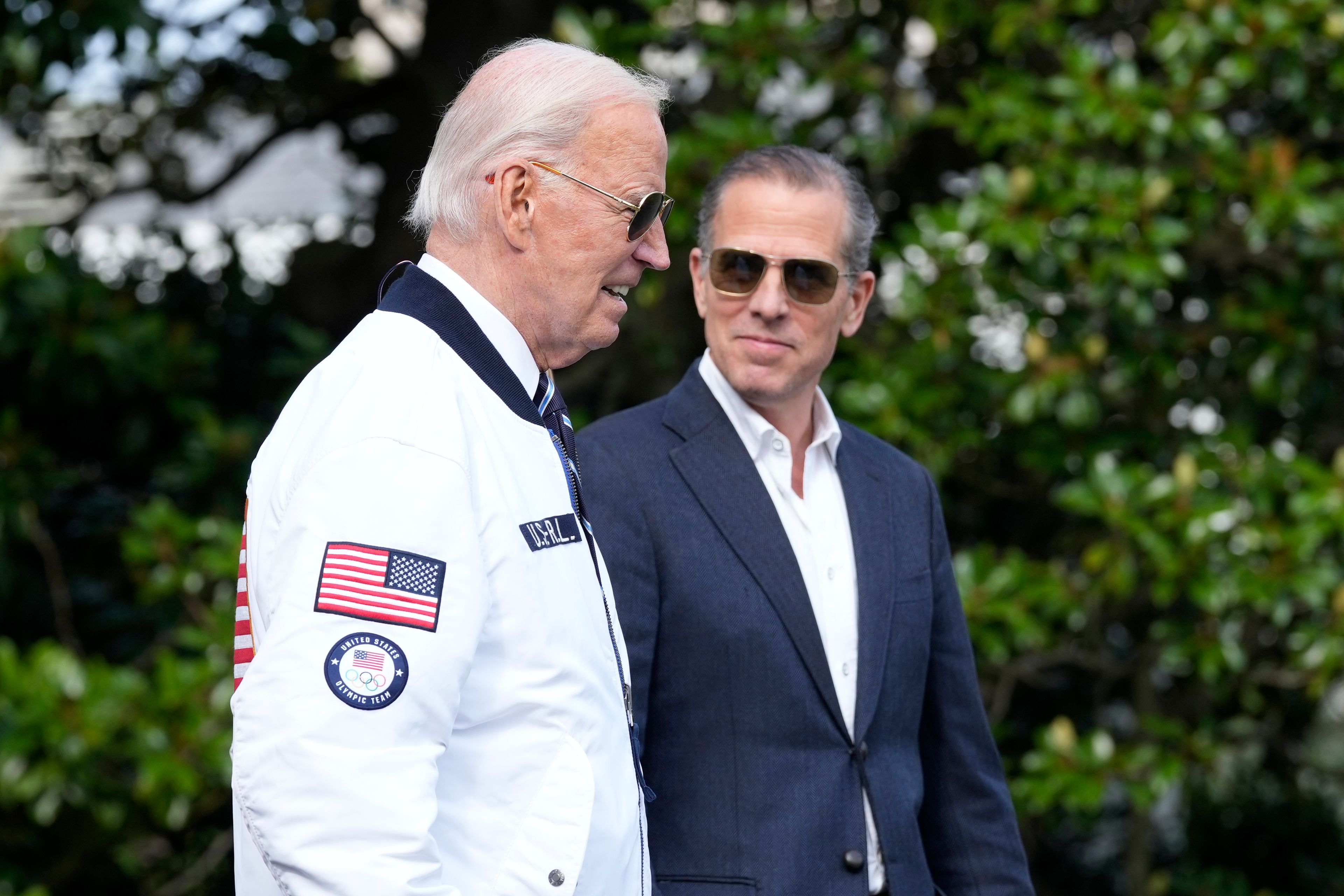 FILE - President Joe Biden, wearing a Team USA jacket and walking with his son Hunter Biden, heads toward Marine One on the South Lawn of the White House in Washington, July 26, 2024. (AP Photo/Susan Walsh, File)