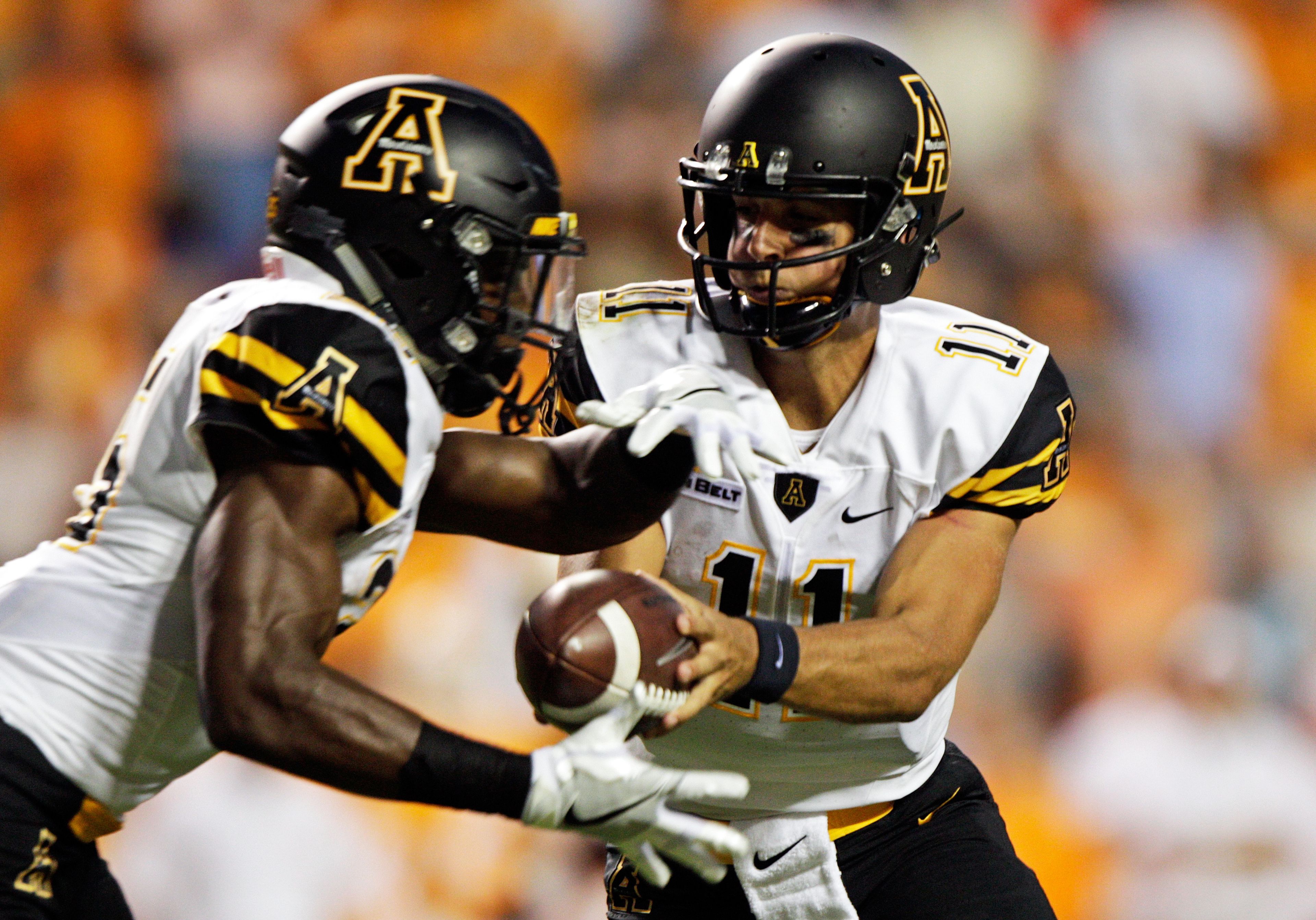 Appalachian State quarterback Taylor Lamb (11) hands the ball off to running back Jalin Moore during the first half of an NCAA college football game against Tennessee Thursday, Sept. 1, 2016 in Knoxville, Tenn. (AP Photo/Wade Payne)