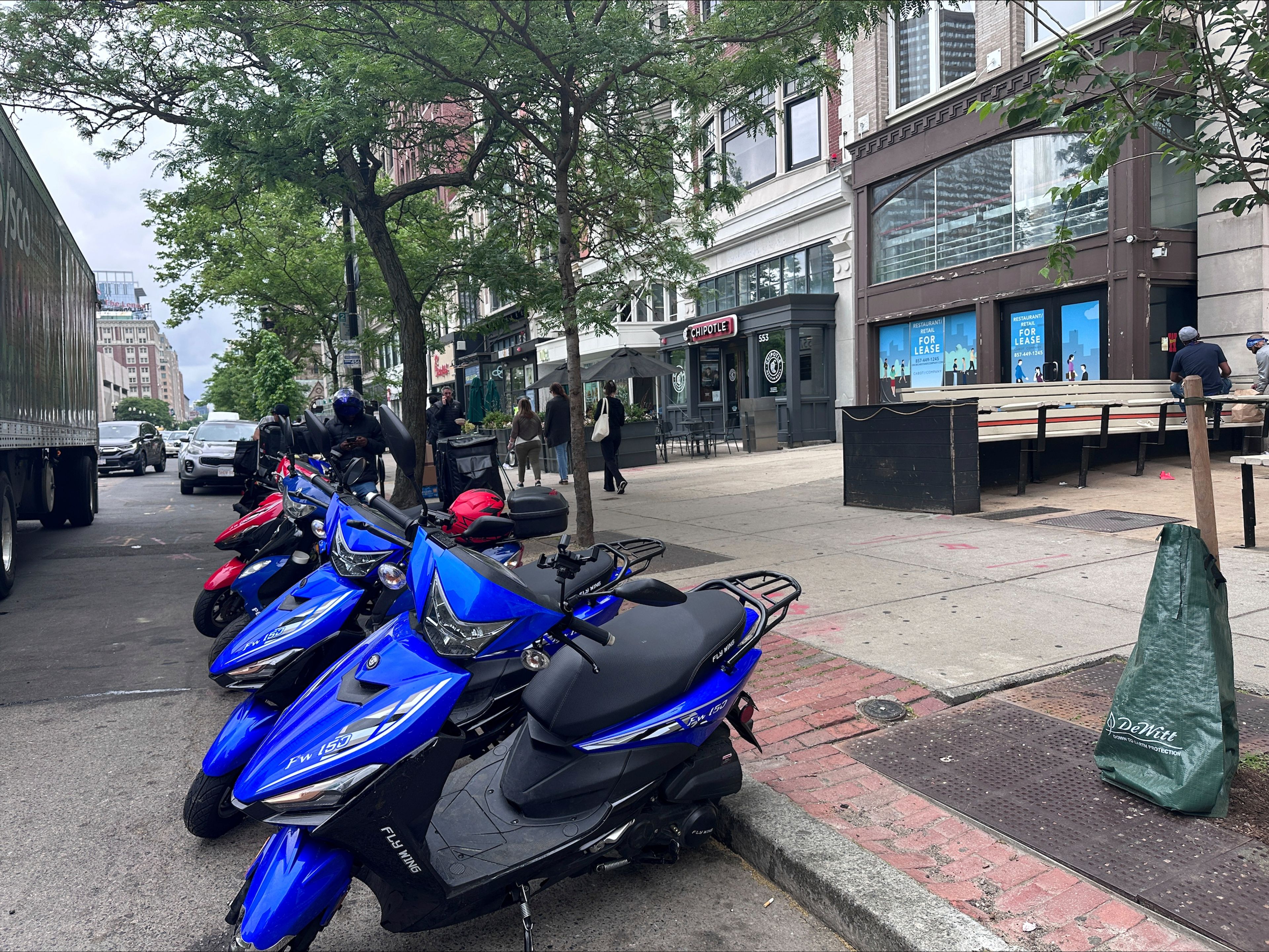 Delivery scooters are parked as drivers wait to pick up food for delivery, Thursday, June 6, 2024, in Boston. Boston and New York are cracking down on unlawful drivers, whom they say are ignoring traffic laws and making city streets more dangerous.