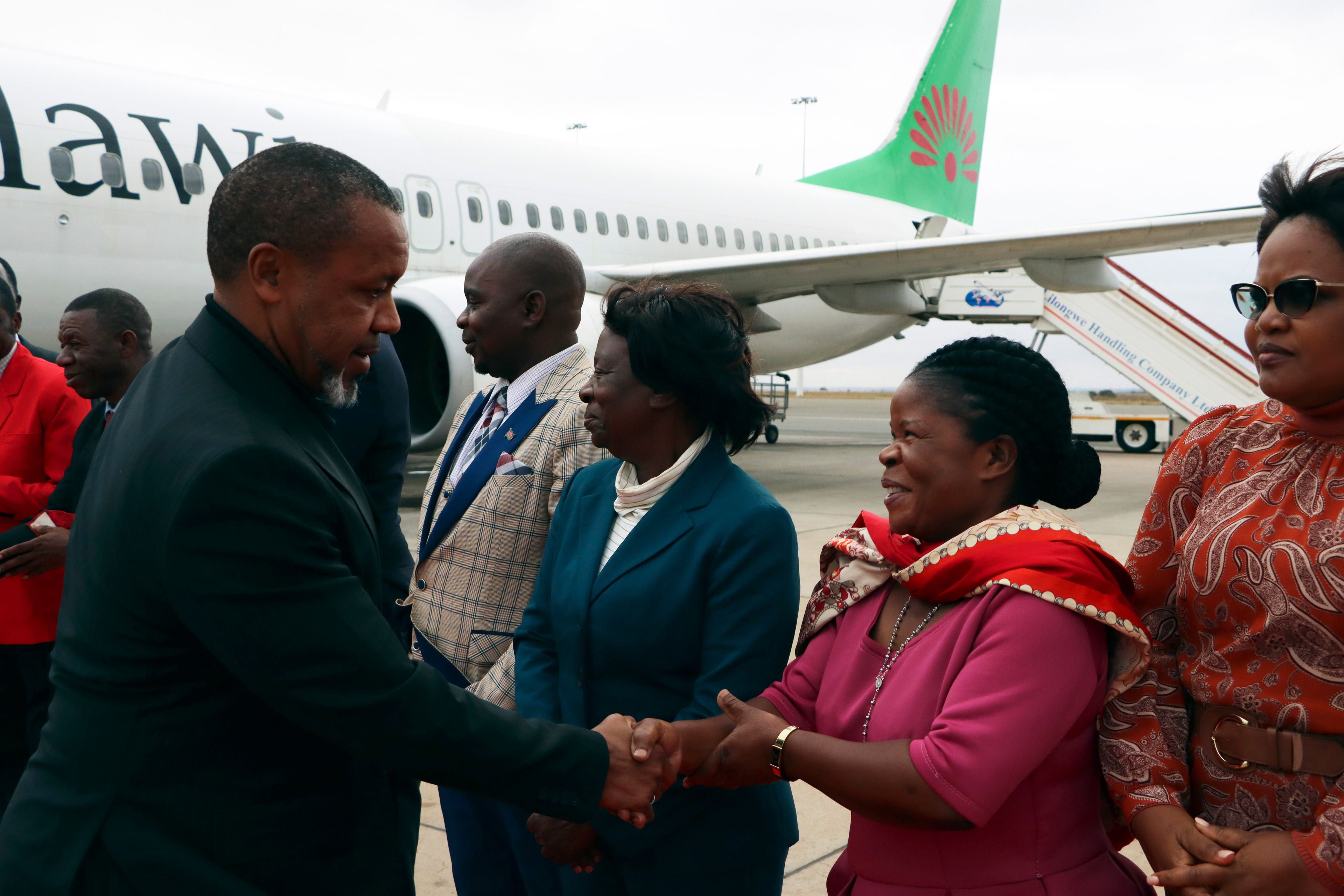 Malawi Vice President Saulos Chilima, left, greets government officials upon his return from South Korea in Lillongwe, Sunday, June 9, 2024. A military plane carrying Malawi's vice president and nine others went missing Monday and a search was underway, the president's office said. The plane carrying 51-year-old Vice President Saulos Chilima left the capital, Lilongwe, but failed to make its scheduled landing at Mzuzu International Airport about 370 kilometers (230 miles) to the north around 45 minutes later.