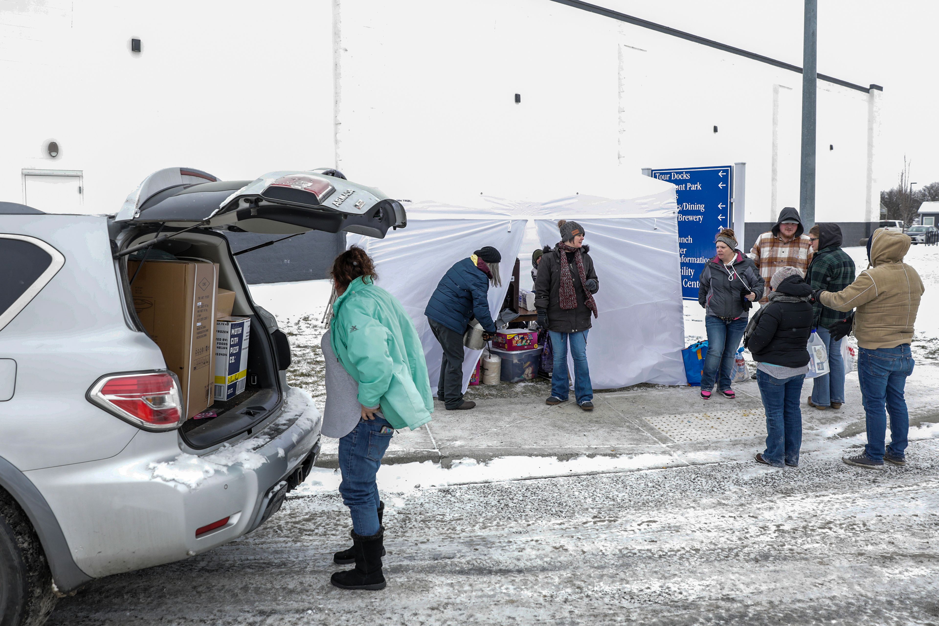 People drop off donations at a warming tent outside the Chef Store Sunday in Clarkston.