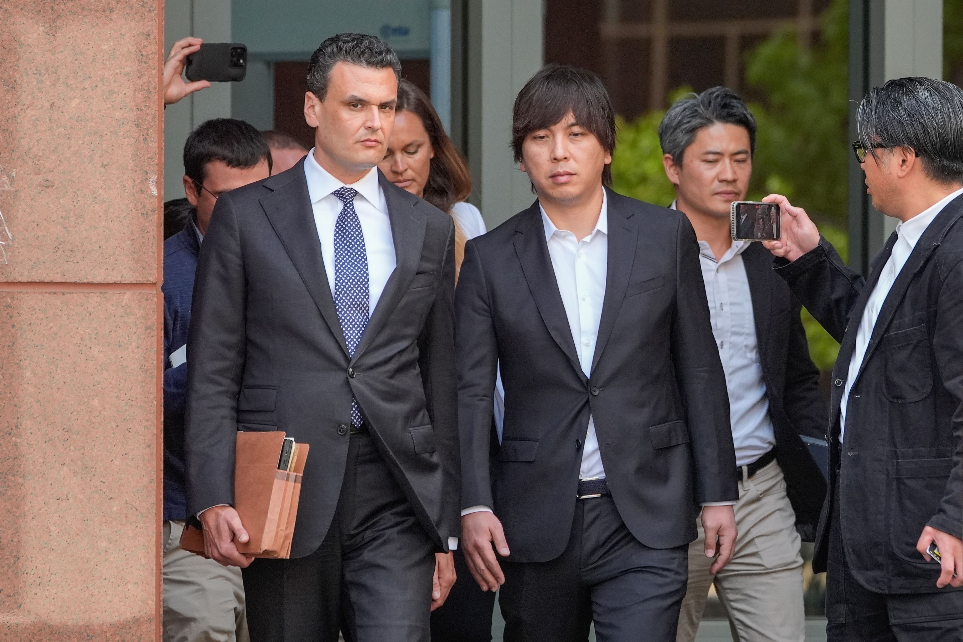 FILE - Ippei Mizuhara, center, the former longtime interpreter for the Los Angeles Dodgers baseball star Shohei Ohtani, leaves federal court following his arraignment, Tuesday, May 14, 2024, in Los Angeles. Far left, is his defense attorney, Michael Freedman. Mizuhara is scheduled to plead guilty Tuesday, June 4, 2024, to bank and tax fraud in a sports betting case where he is expected to admit to stealing nearly $17 million from the Japanese baseball player.