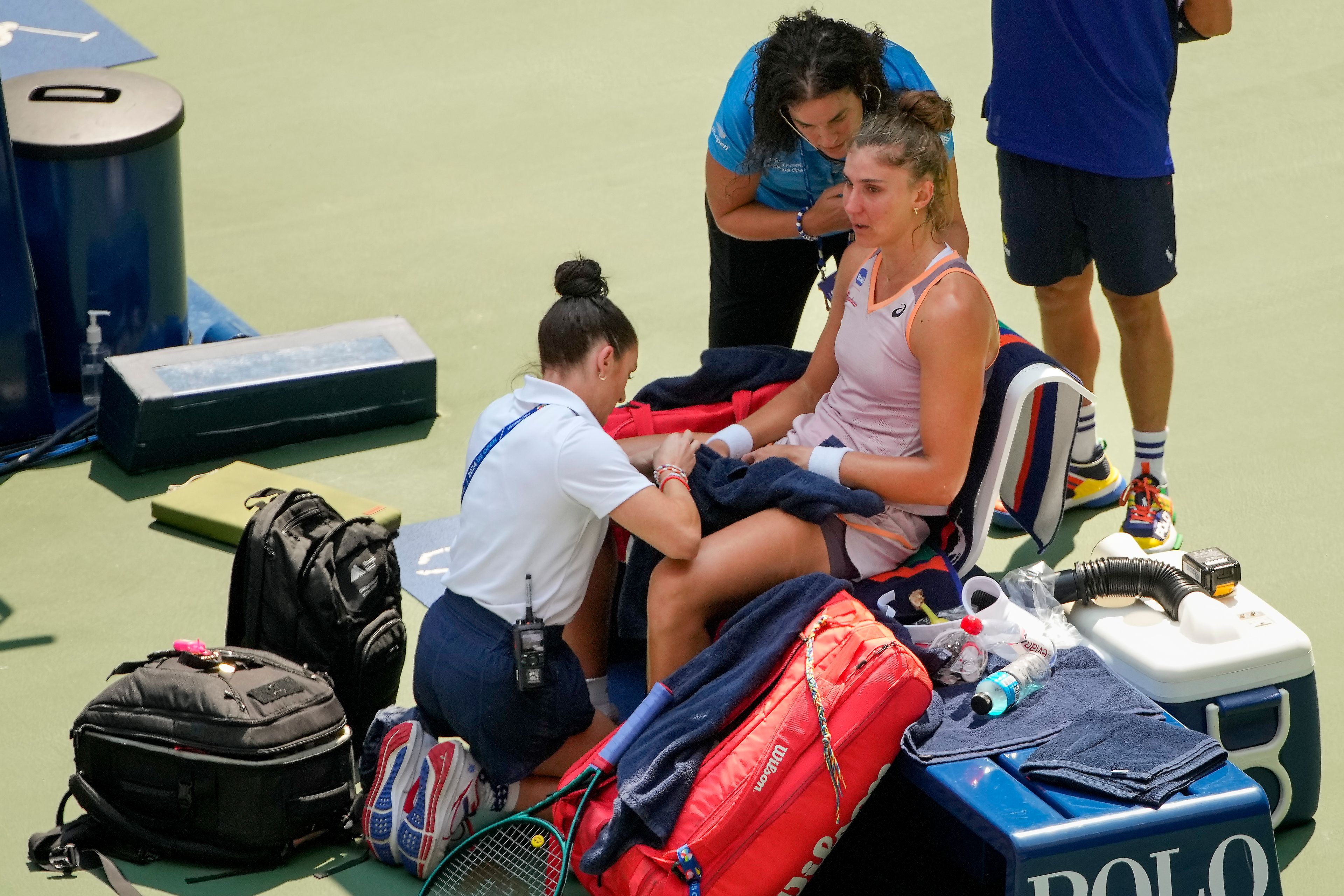 Beatriz Haddad Maia, of Brazil, is checked by medical personnel during the second set against Karolina Muchova, of the Czech Republic, during the quarterfinals of the U.S. Open tennis championships, Wednesday, Sept. 4, 2024, in New York.